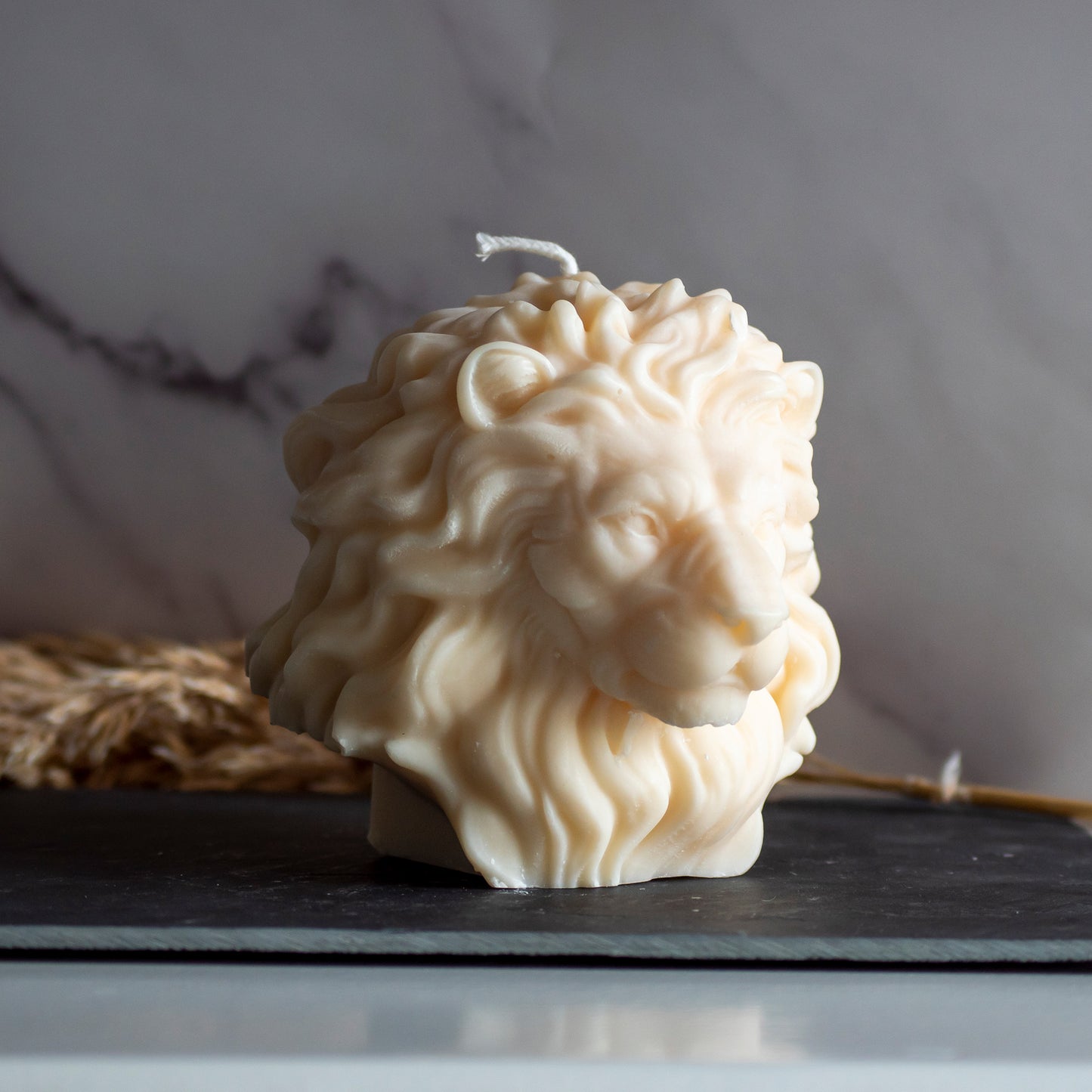 Beigekleurige Lion Light kaars in rustige, natuurlijke setting