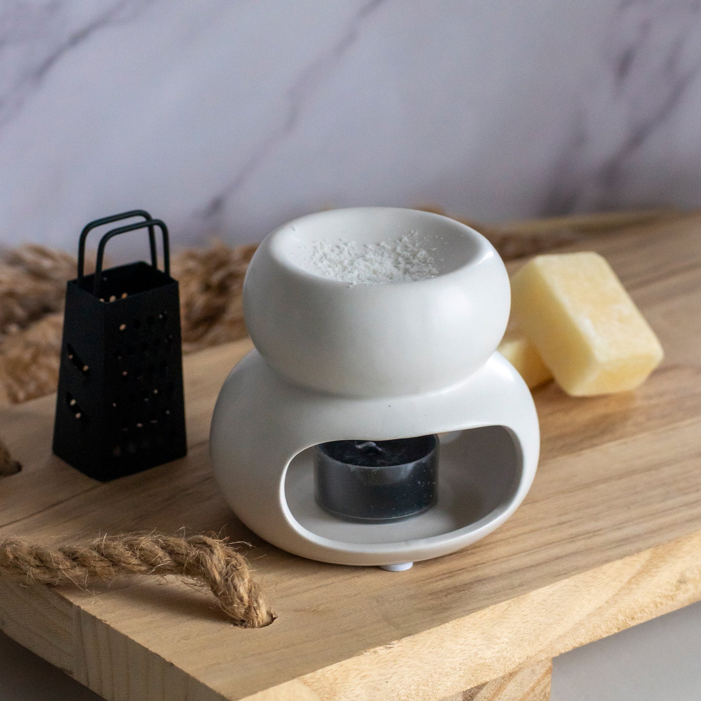 Witte brander voor amberblokjes schaafsel op houten plank met toebehoren ernaast