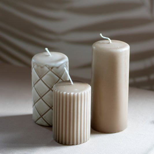 Set Ami met drie kaarsen in cappuccino op neutrale achtergrond en rustige lichtval