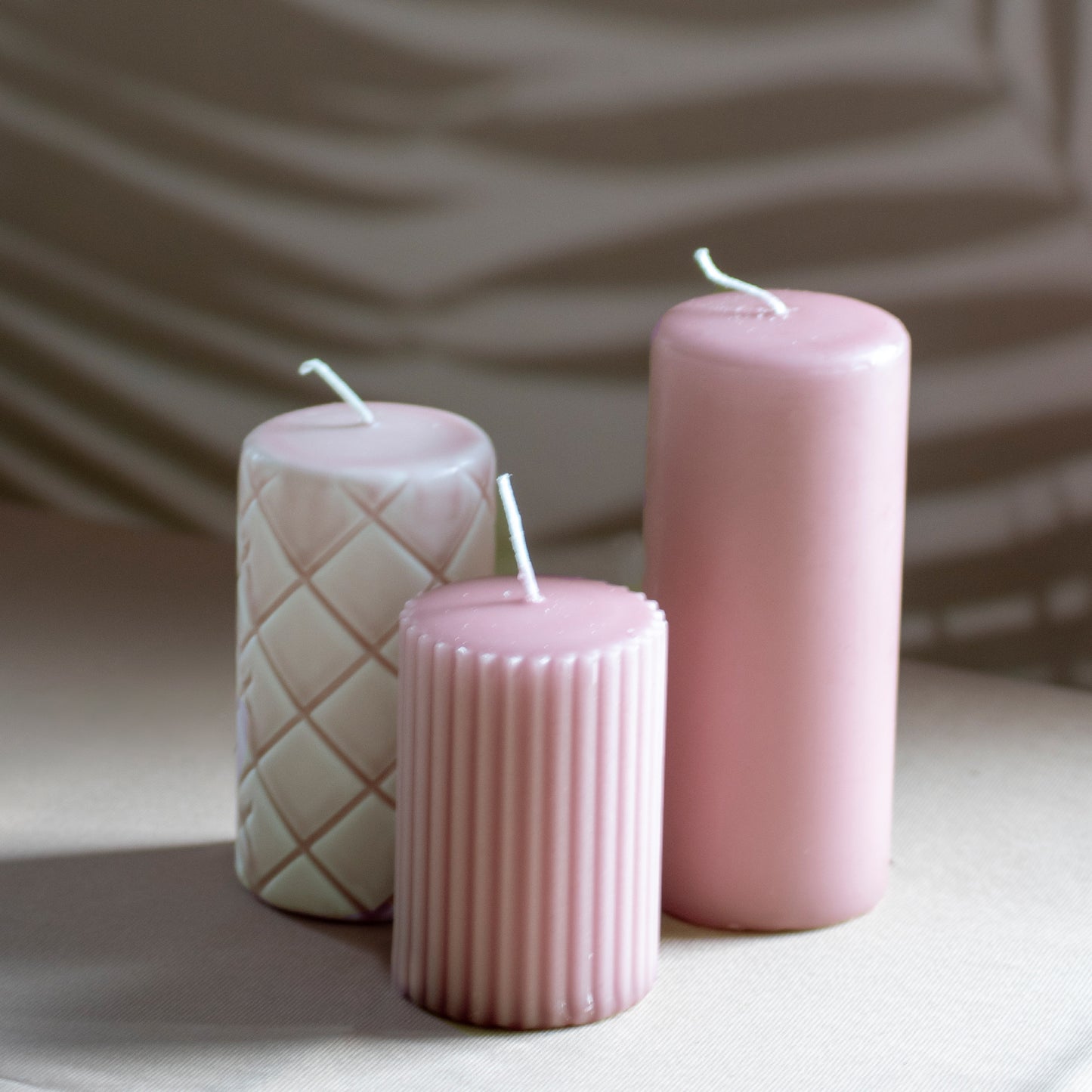 Set Ami met drie kaarsen in oudroze op neutrale achtergrond en rustige lichtval