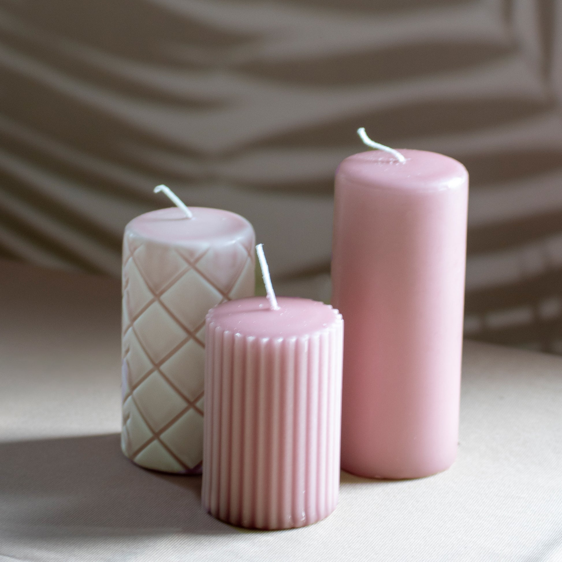 Set Ami met drie kaarsen in oudroze op neutrale achtergrond en rustige lichtval