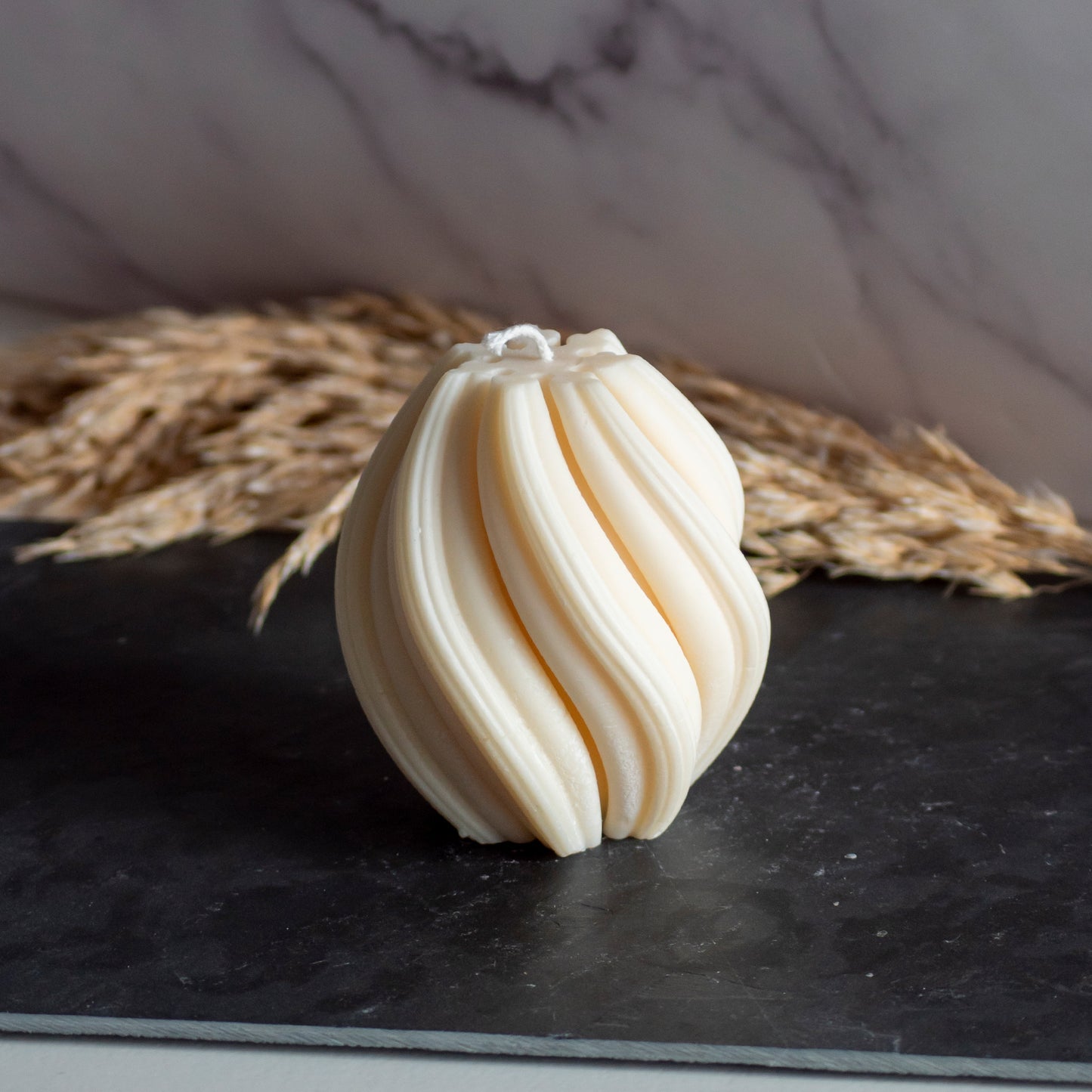 Beigekleurige Flow Flame kaars in rustige, natuurlijke setting