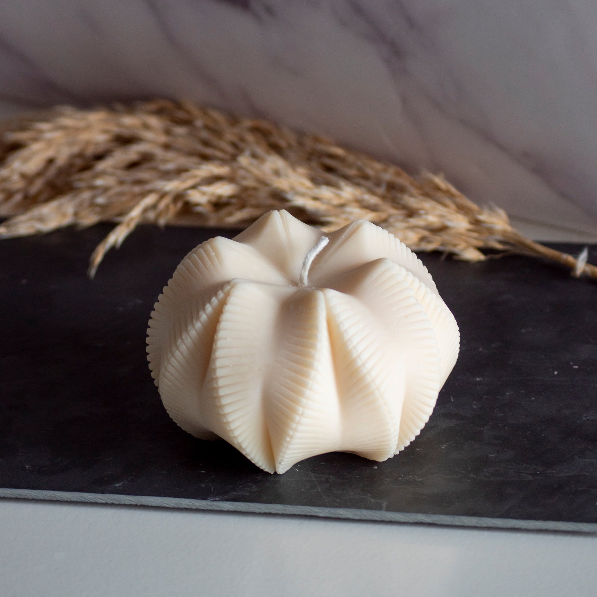 Beigekleurige Fold Bloom kaars in rustige, natuurlijke setting