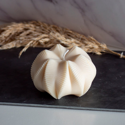 Beigekleurige Fold Bloom kaars in rustige, natuurlijke setting