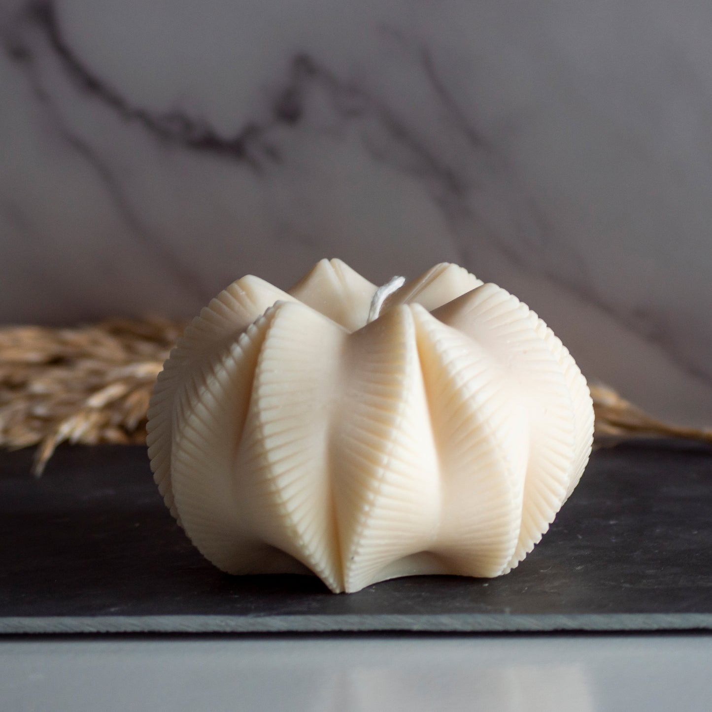 Beigekleurige Fold Bloom kaars in rustige, natuurlijke setting