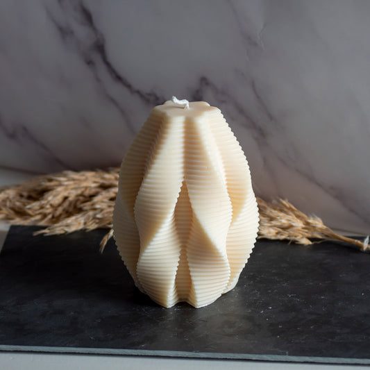 Beigekleurige Honey Fold kaars in rustige, natuurlijke setting