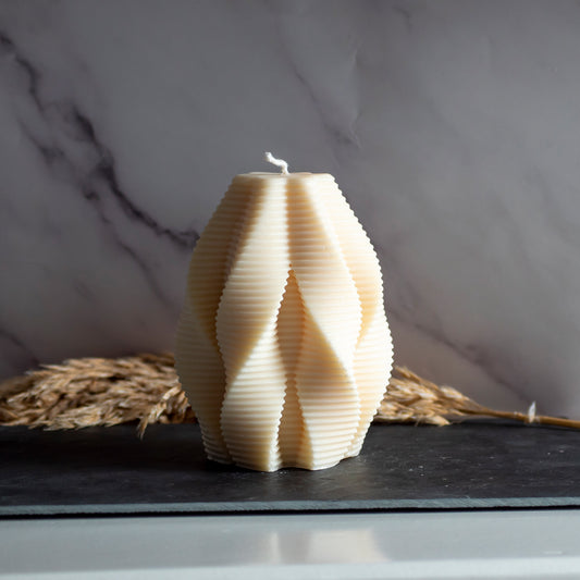 Beigekleurige Honey Fold kaars in rustige, natuurlijke setting