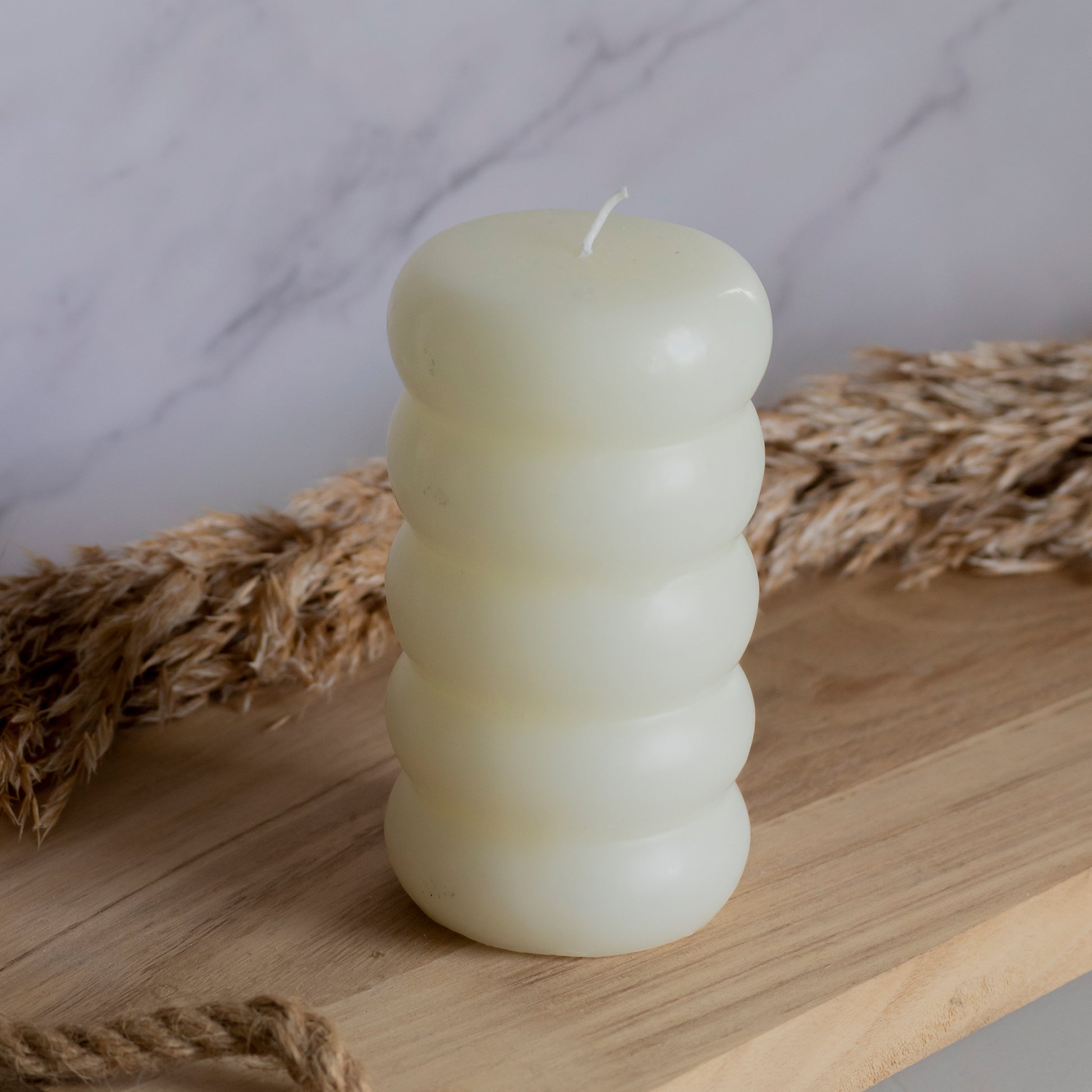 Hoge ringelkaars in beige kleur op houten plank met tarwe als decoratie