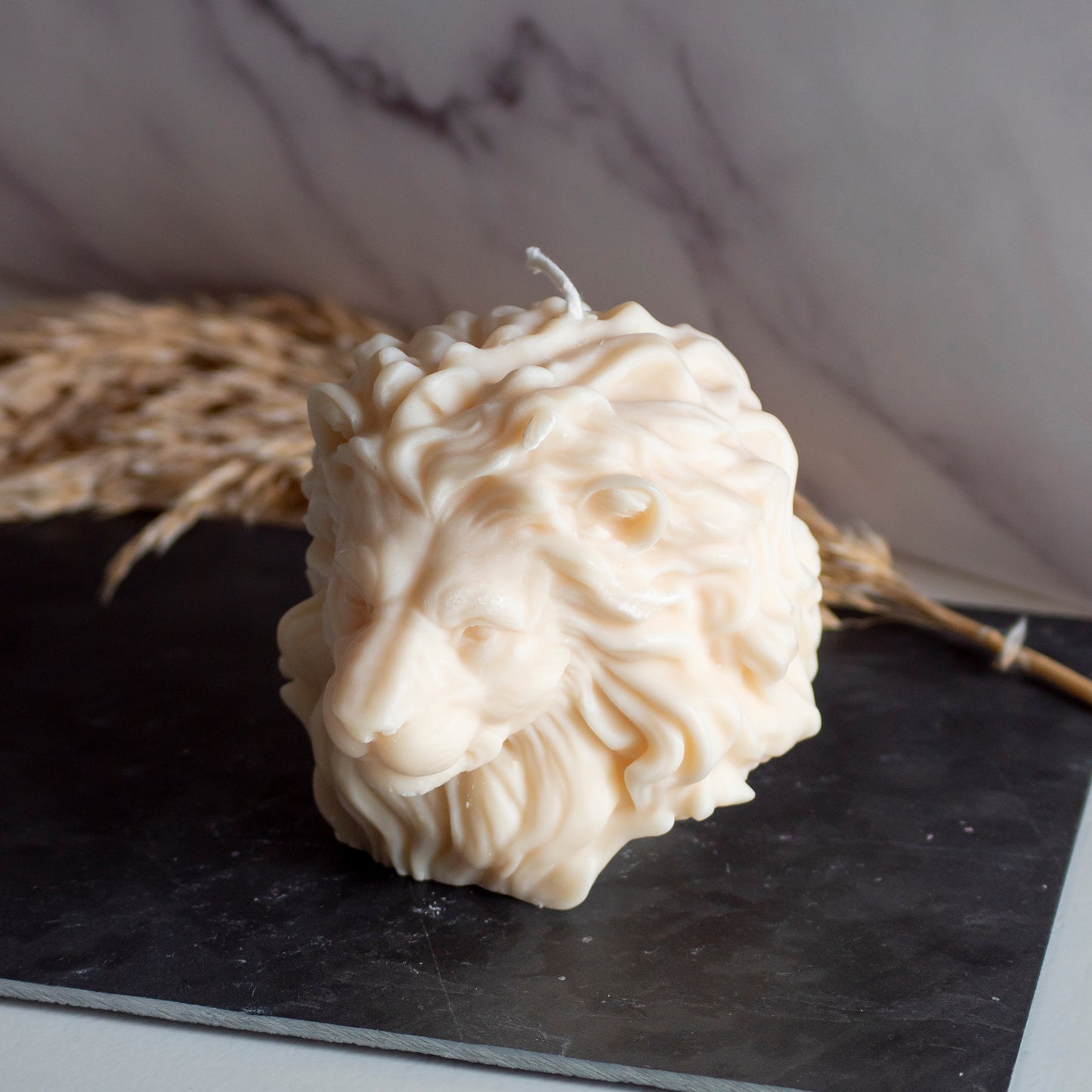 Beigekleurige Lion Light kaars in rustige, natuurlijke setting