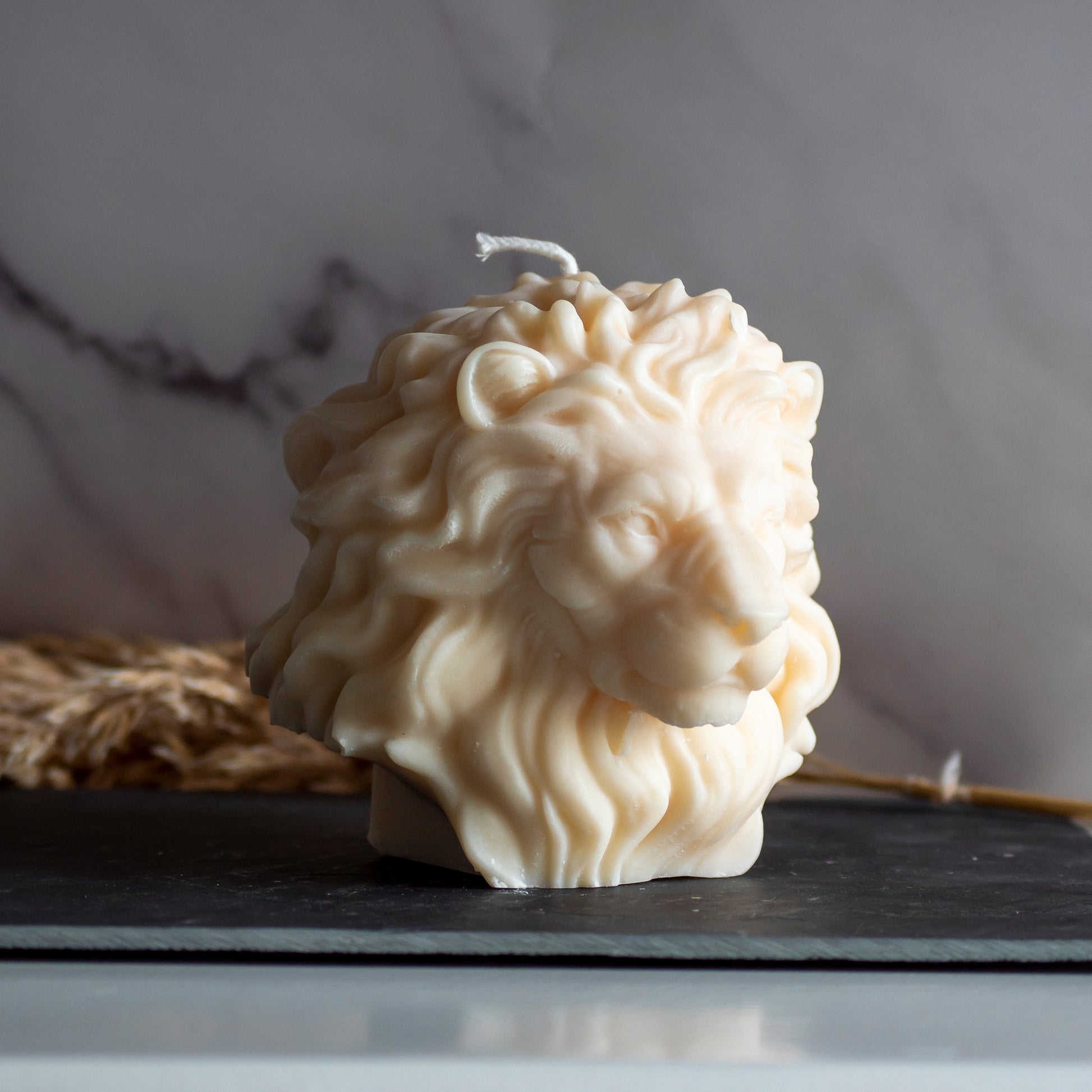 Beigekleurige Lion Light kaars in rustige, natuurlijke setting