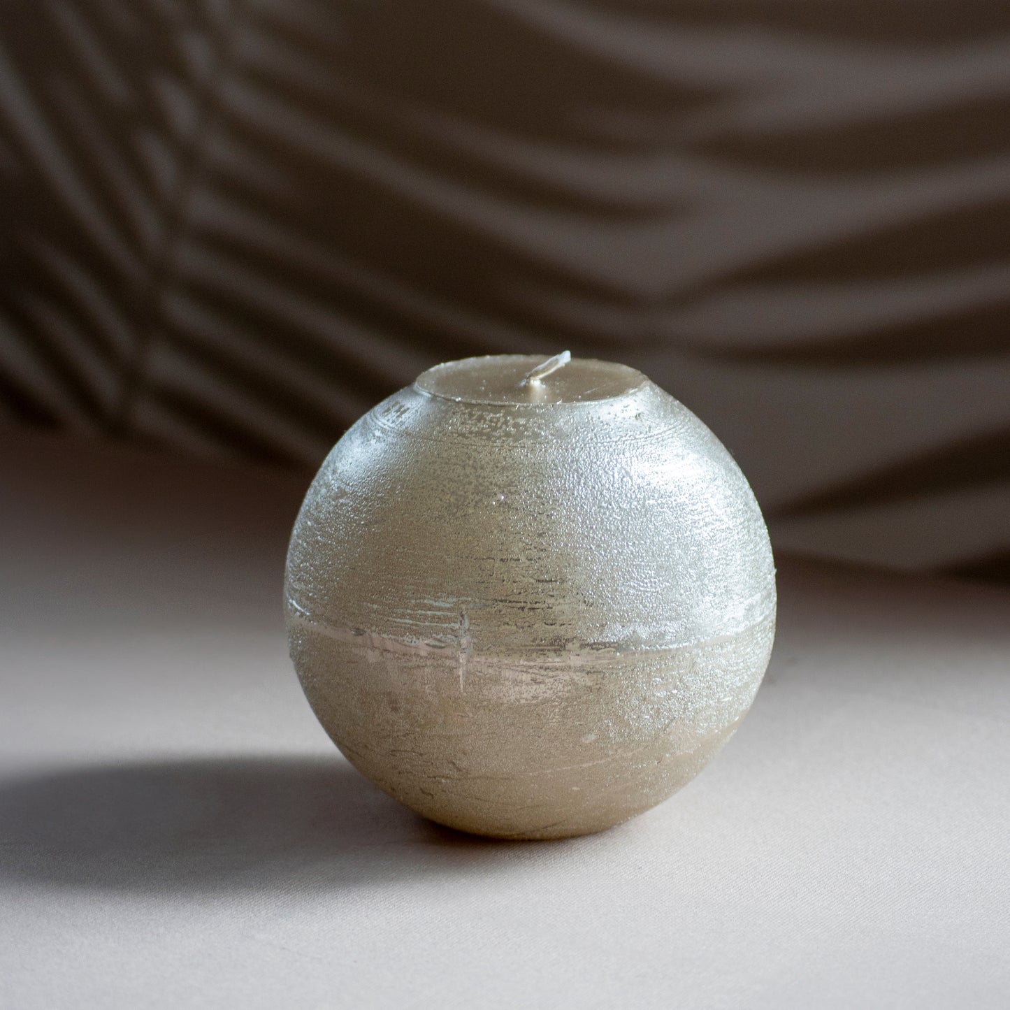 Kaars Melo in kleur champagne metallic op neutrale achtergrond en rustige lichtval