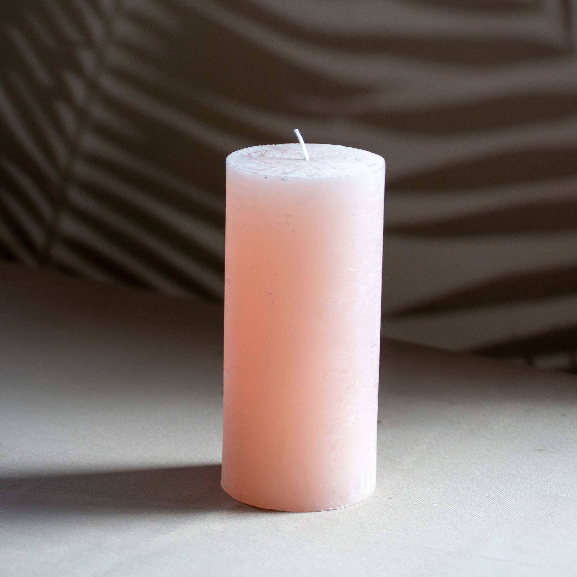Kaars Noa in kleur zachtroze op neutrale achtergrond en rustige lichtval