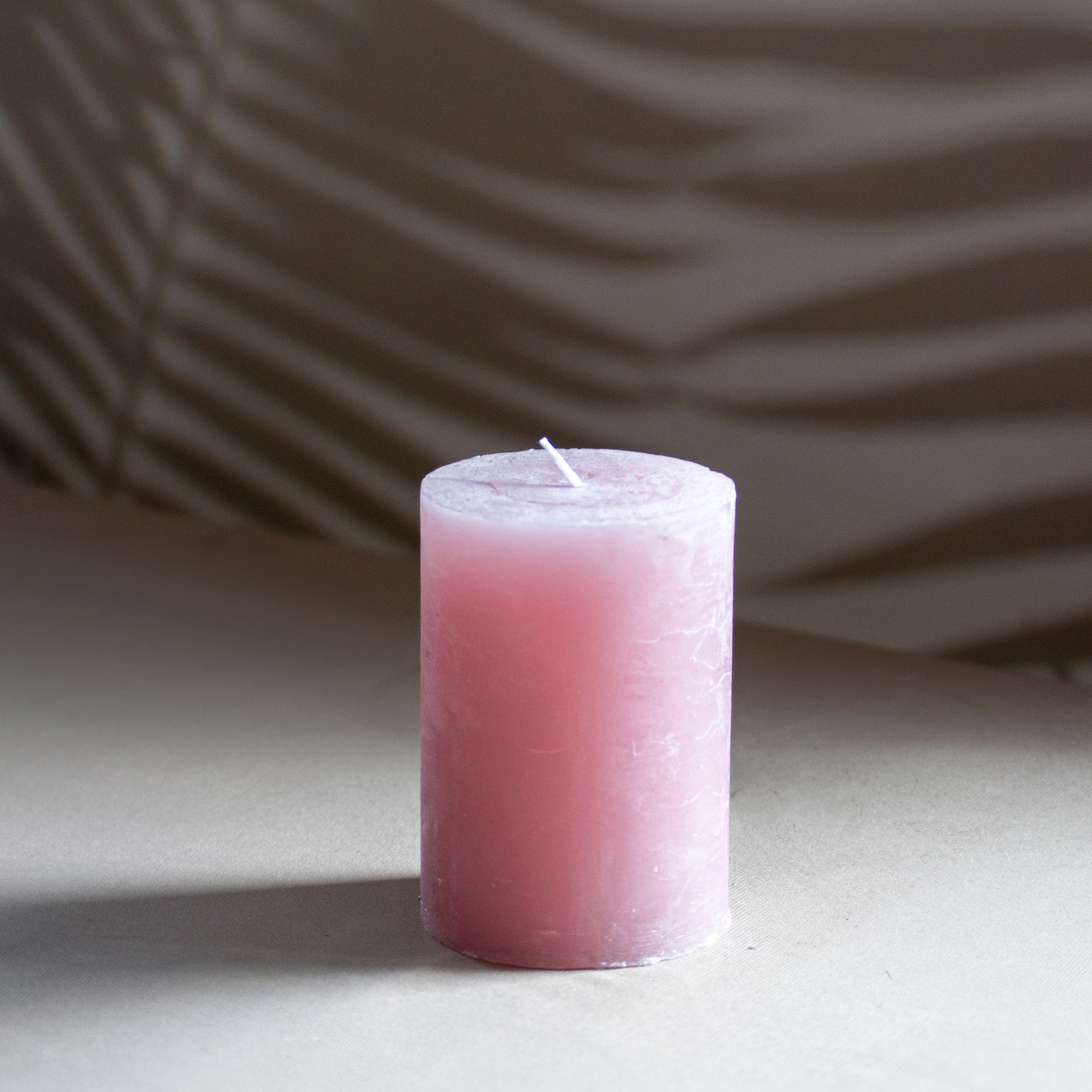 Kaars Roa in kleur oudroze op neutrale achtergrond en rustige lichtval