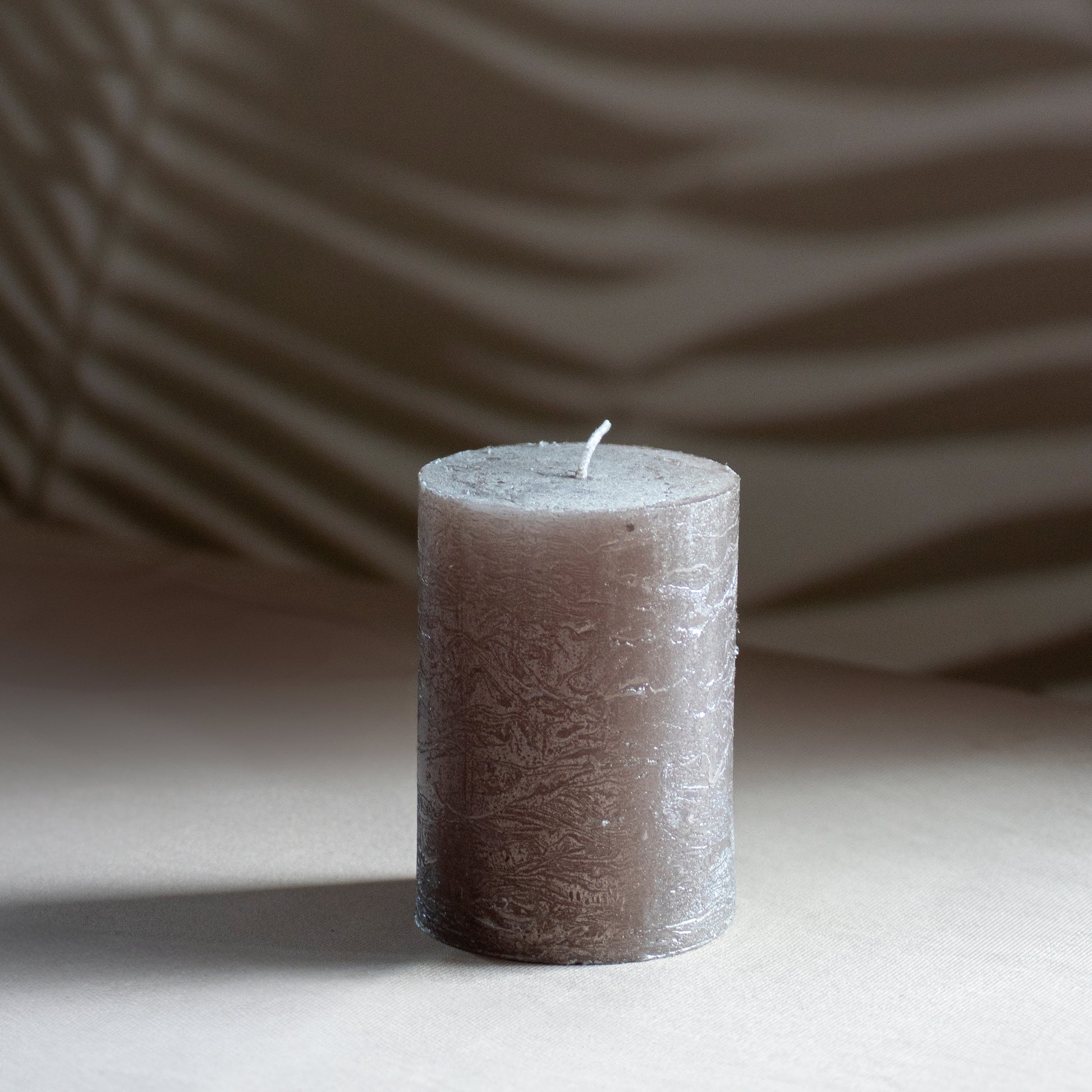 Kaars Roa in kleur steen op neutrale achtergrond en rustige lichtval