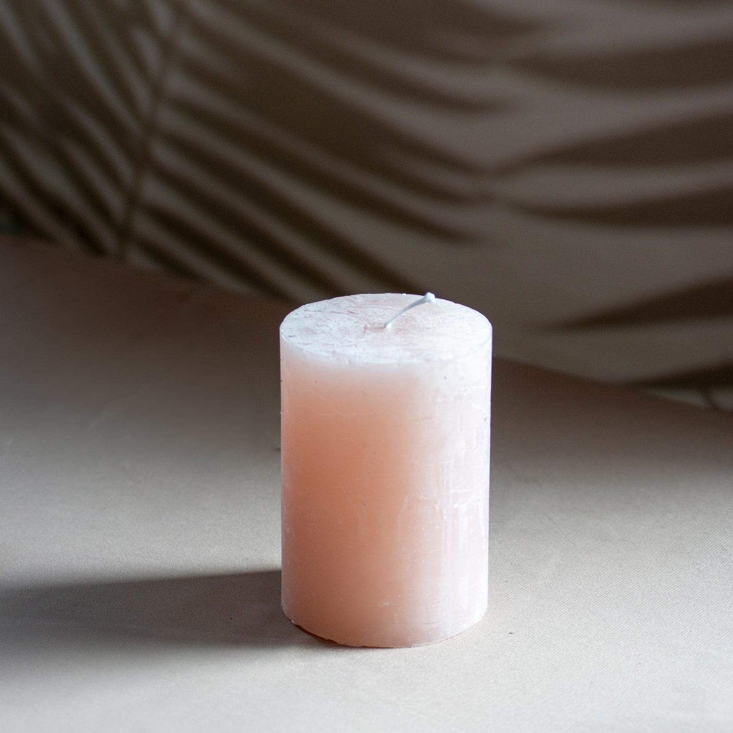 Kaars Roa in kleur zachtroze op neutrale achtergrond en rustige lichtval