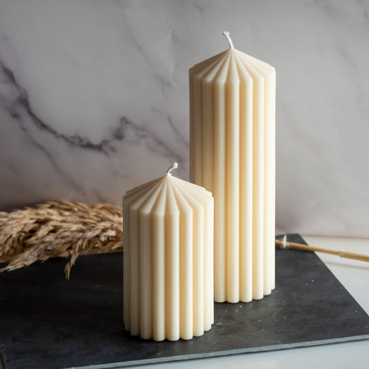 Twee beigekleurige Still Light kaarsen in rustige, natuurlijke setting