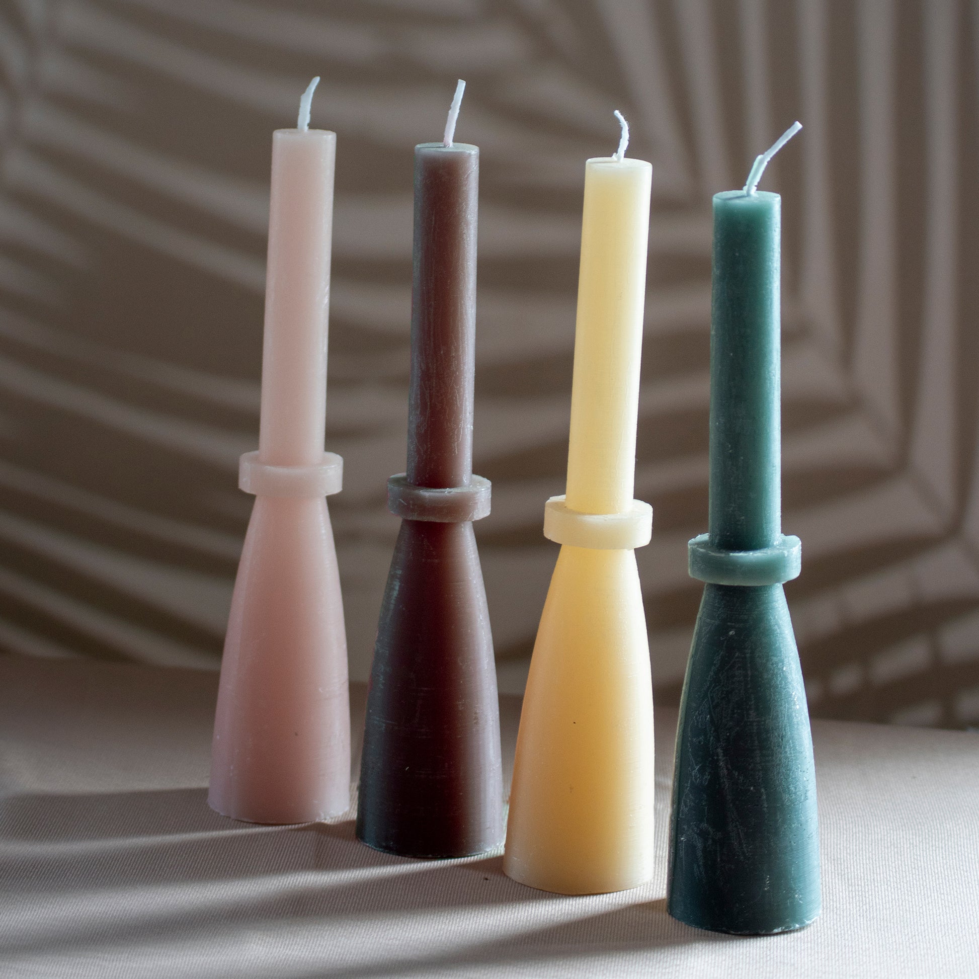 Vier kaarsen Tall Glow op neutrale achtergrond en rustige lichtval