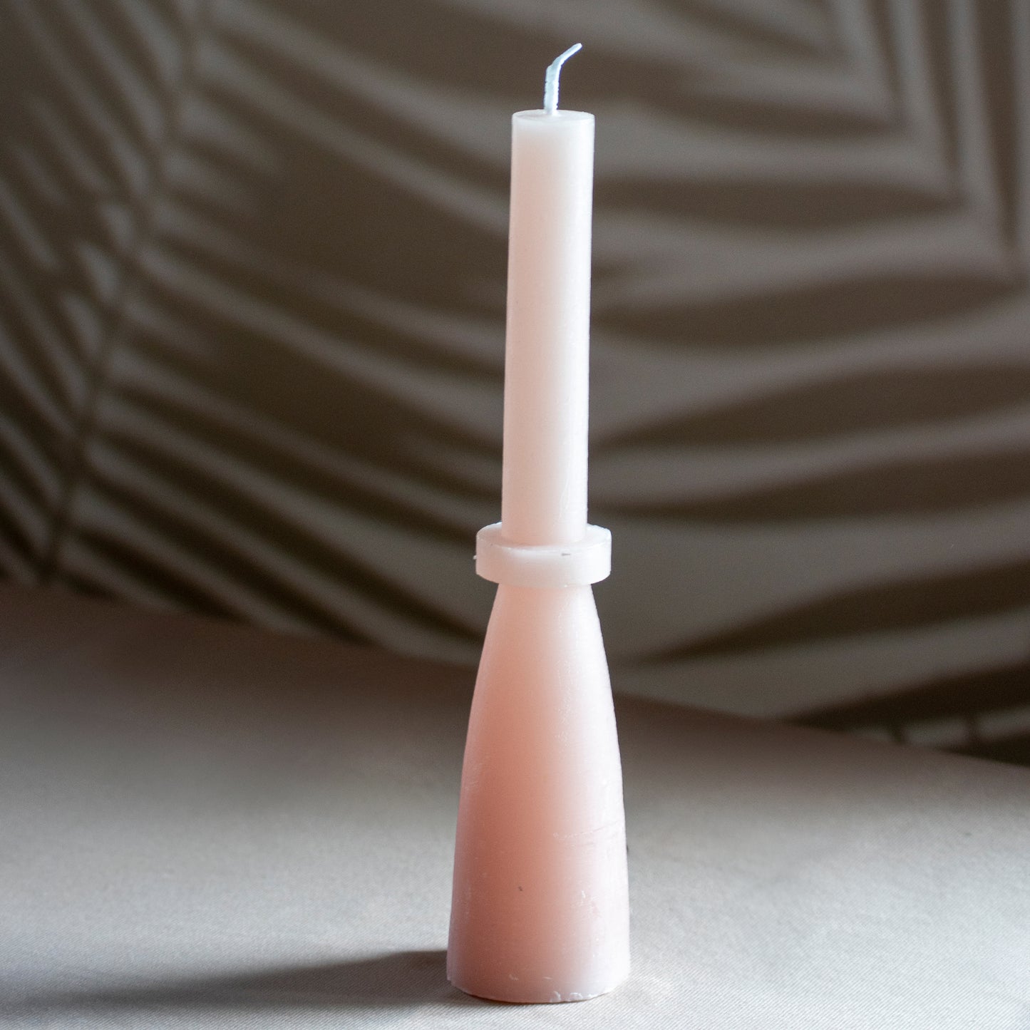 Kaars Tall Glow in kleur zachtroze op neutrale achtergrond en rustige lichtval