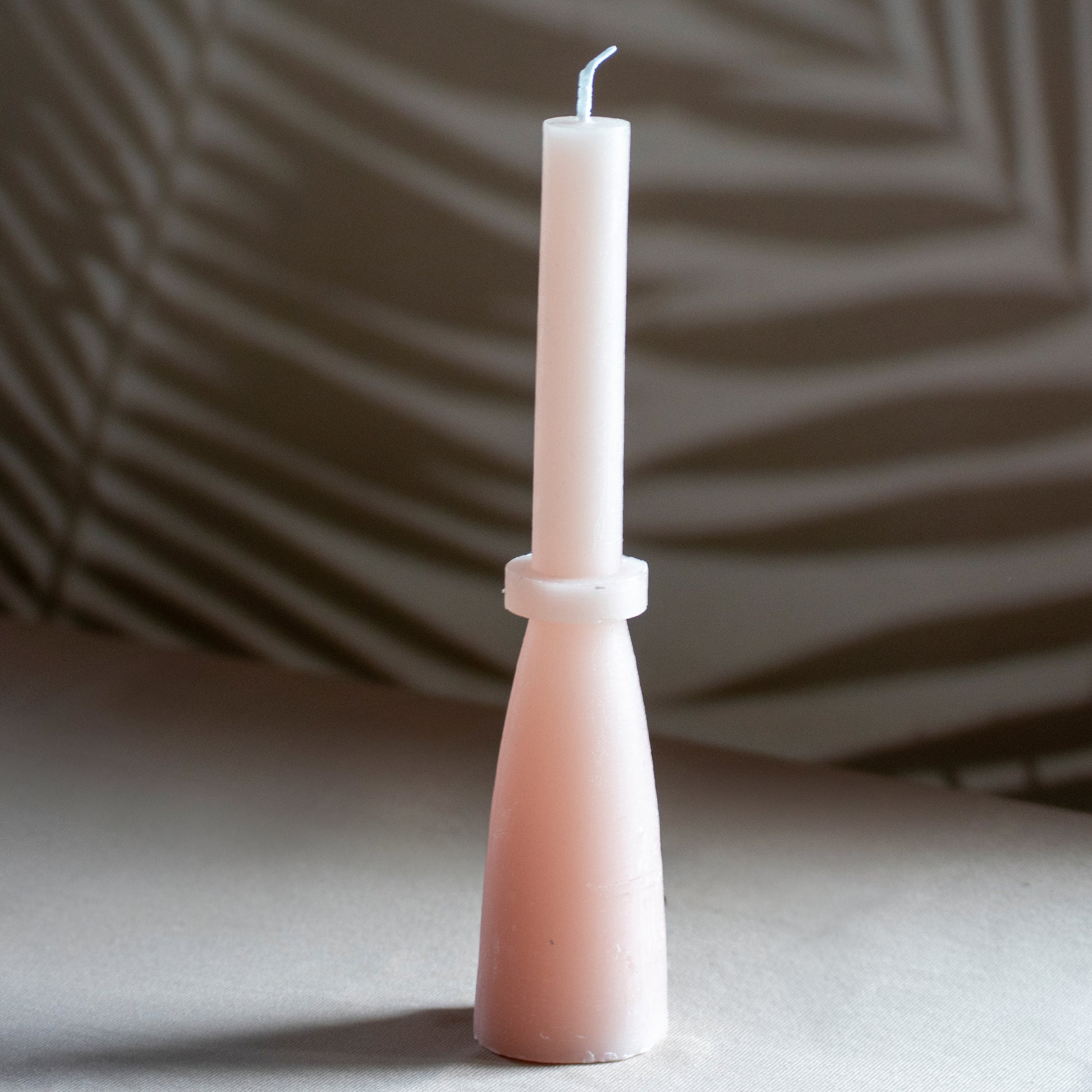 Kaars Tall Glow in kleur zachtroze op neutrale achtergrond en rustige lichtval