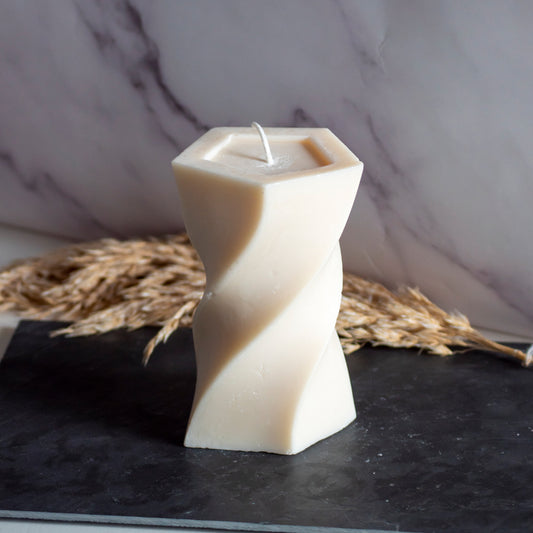 Beigekleurige Twist Tower kaars in rustige, natuurlijke setting