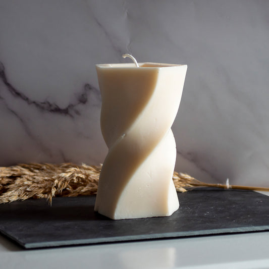 Beigekleurige Twist Tower kaars in rustige, natuurlijke setting