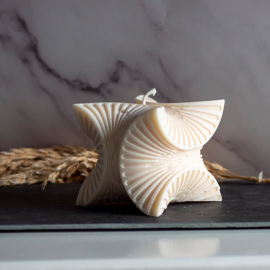 Beigekleurige Wave Harmony kaars in rustige, natuurlijke setting