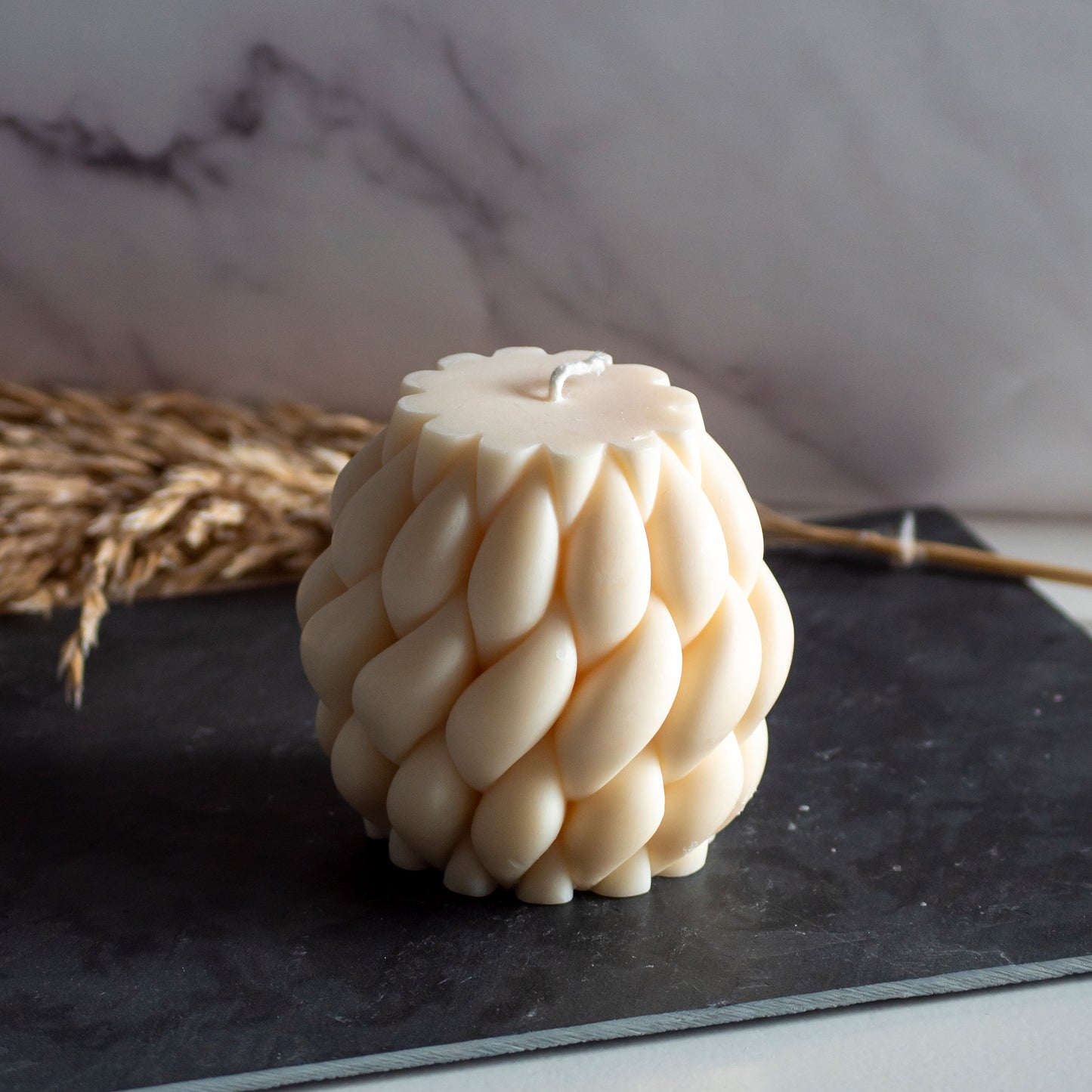 Beigekleurige Wool Twist kaars in rustige, natuurlijke setting