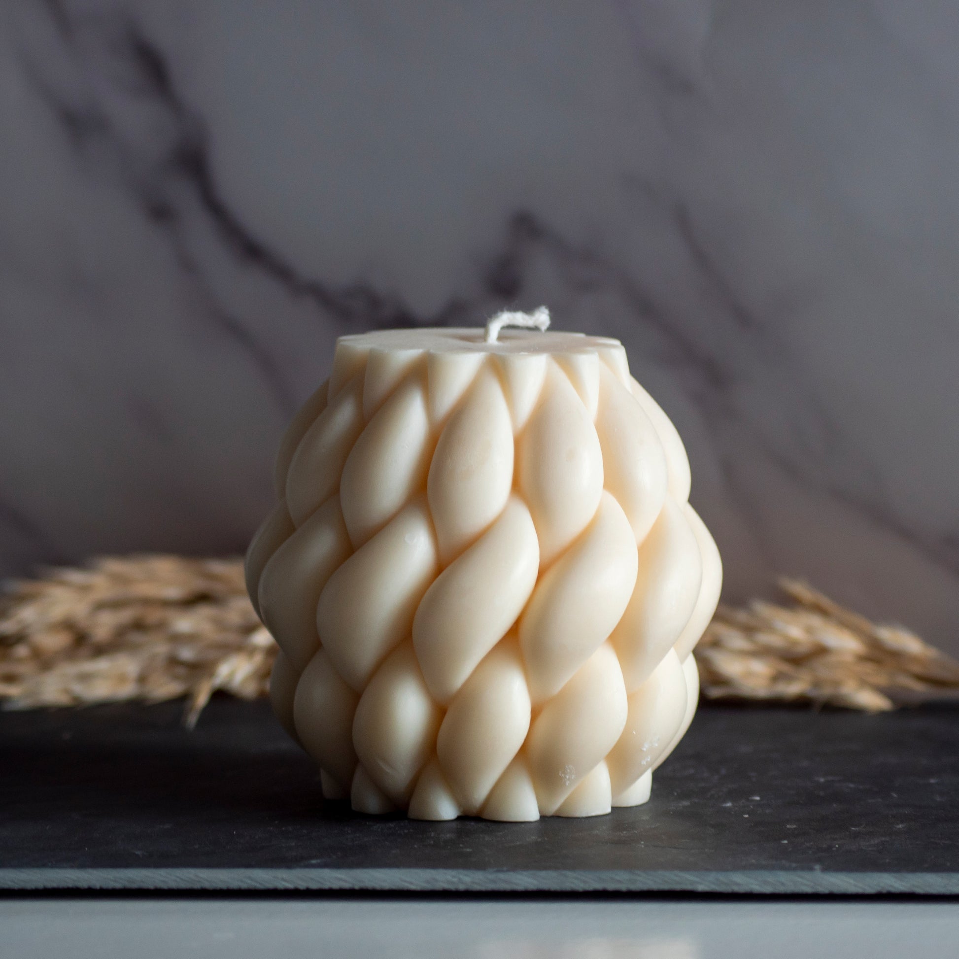 Beigekleurige Wool Twist kaars in rustige, natuurlijke setting