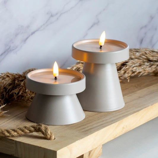 Hoge en lage LED kandelaar in taupe kleur op houten plank met tarwe decoratie