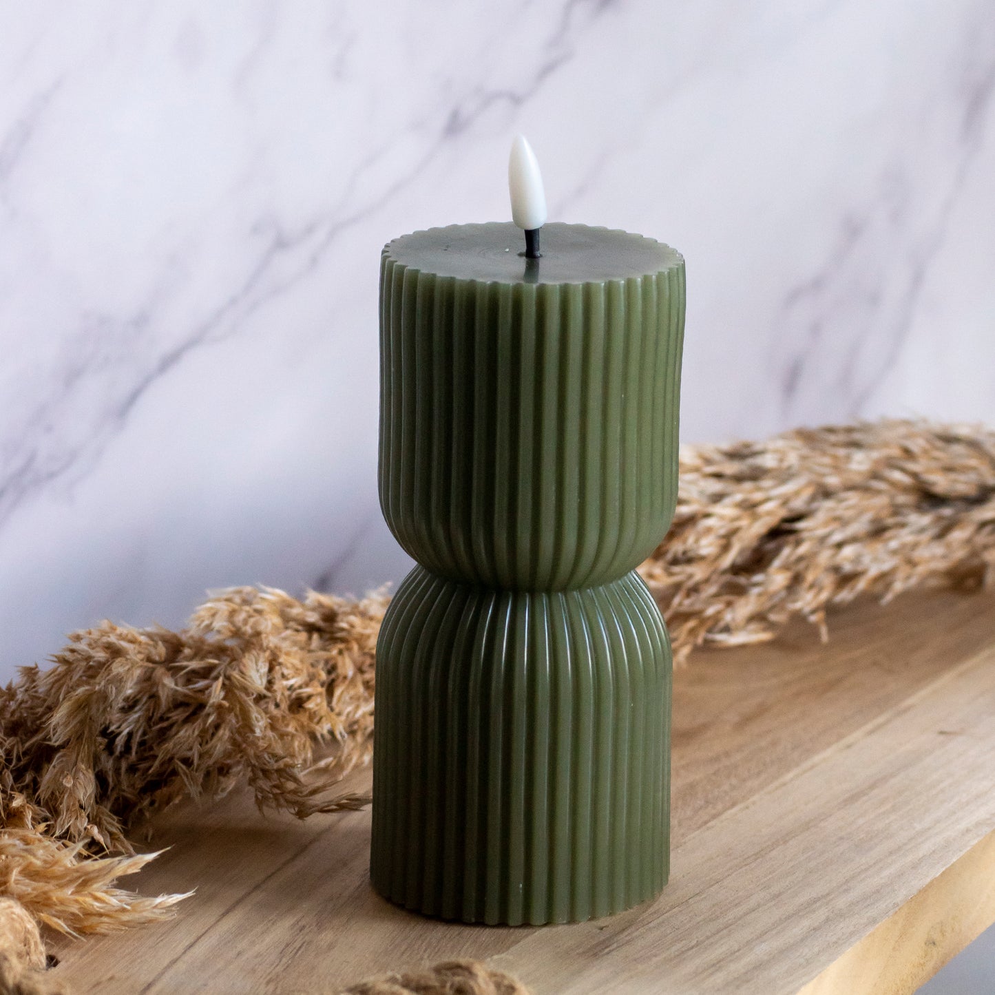Lage LED kaars in groene kleur op houten plank met tarwe als decoratie