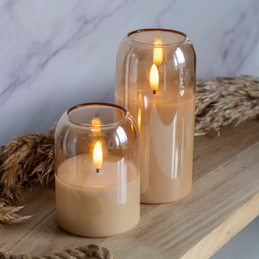 Hoge en lage LED kaarsen in glas in honingkleur op houten plank met tarwe als decoratie