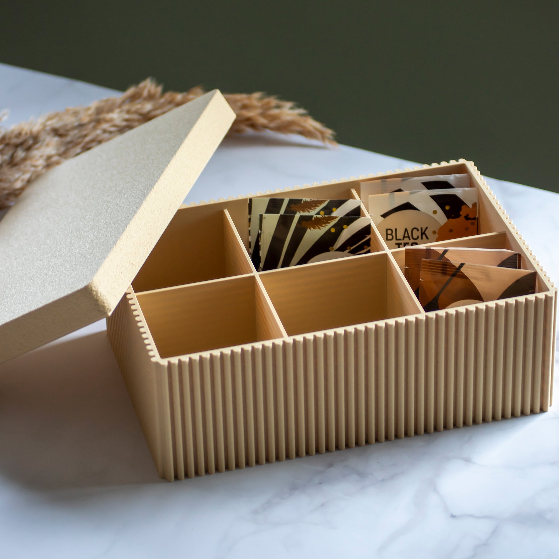 Theedoos Folda in kleur zandgeel op marmeren ondergrond en rustige lichtinval