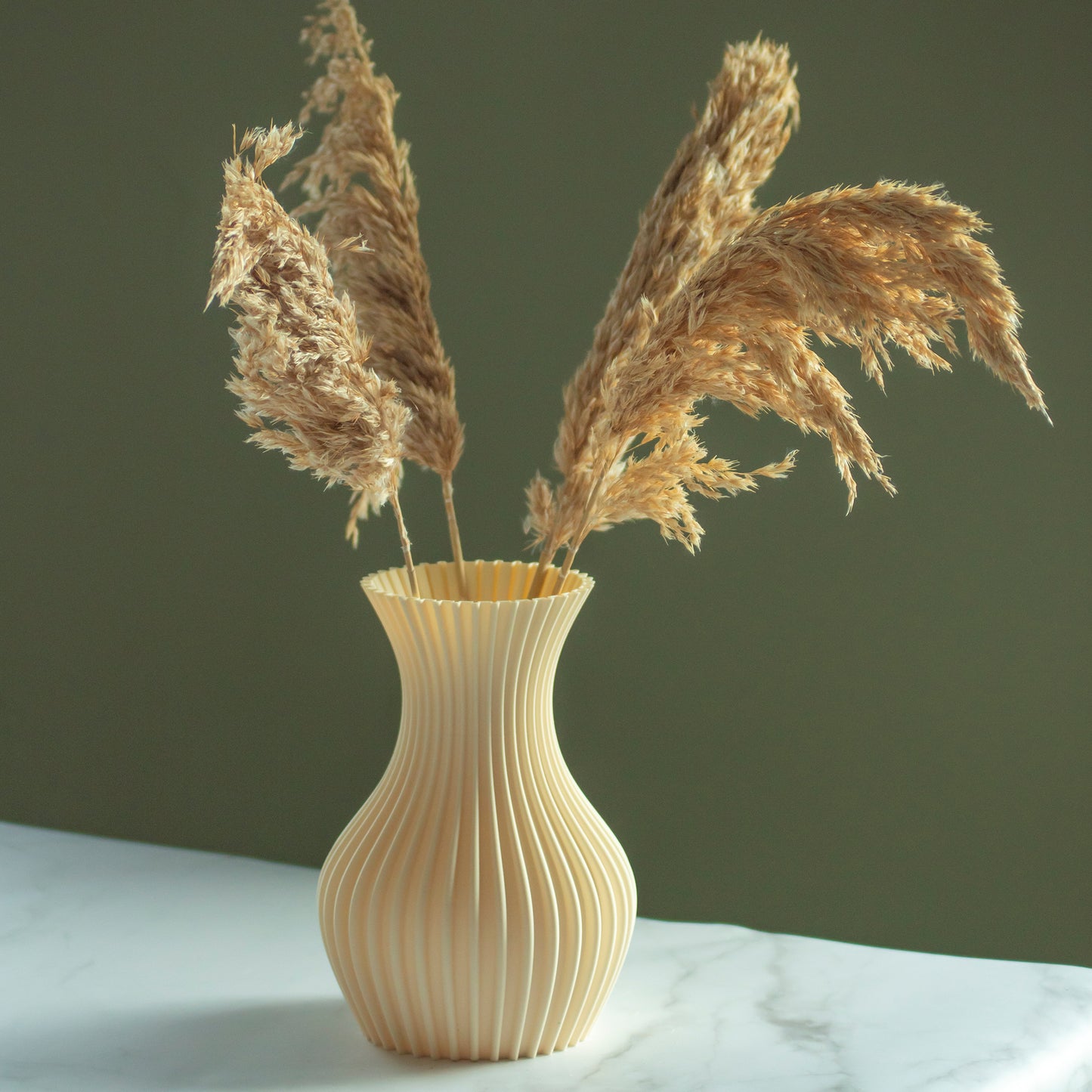 Beige vaas Luva met droogbloemen op marmeren blad en groene achtergrond