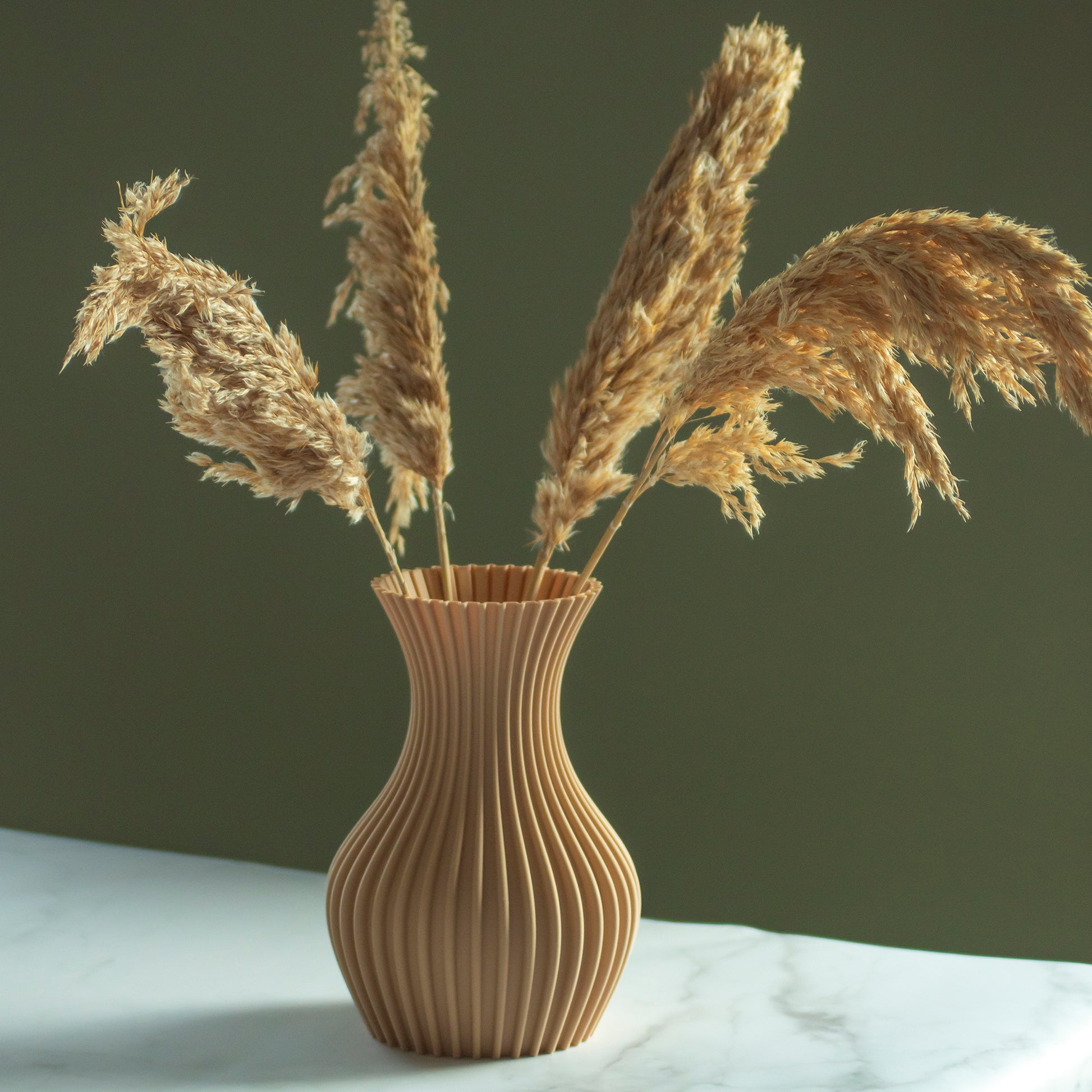 Karamel vaas Luva met droogbloemen op marmeren blad en groene achtergrond