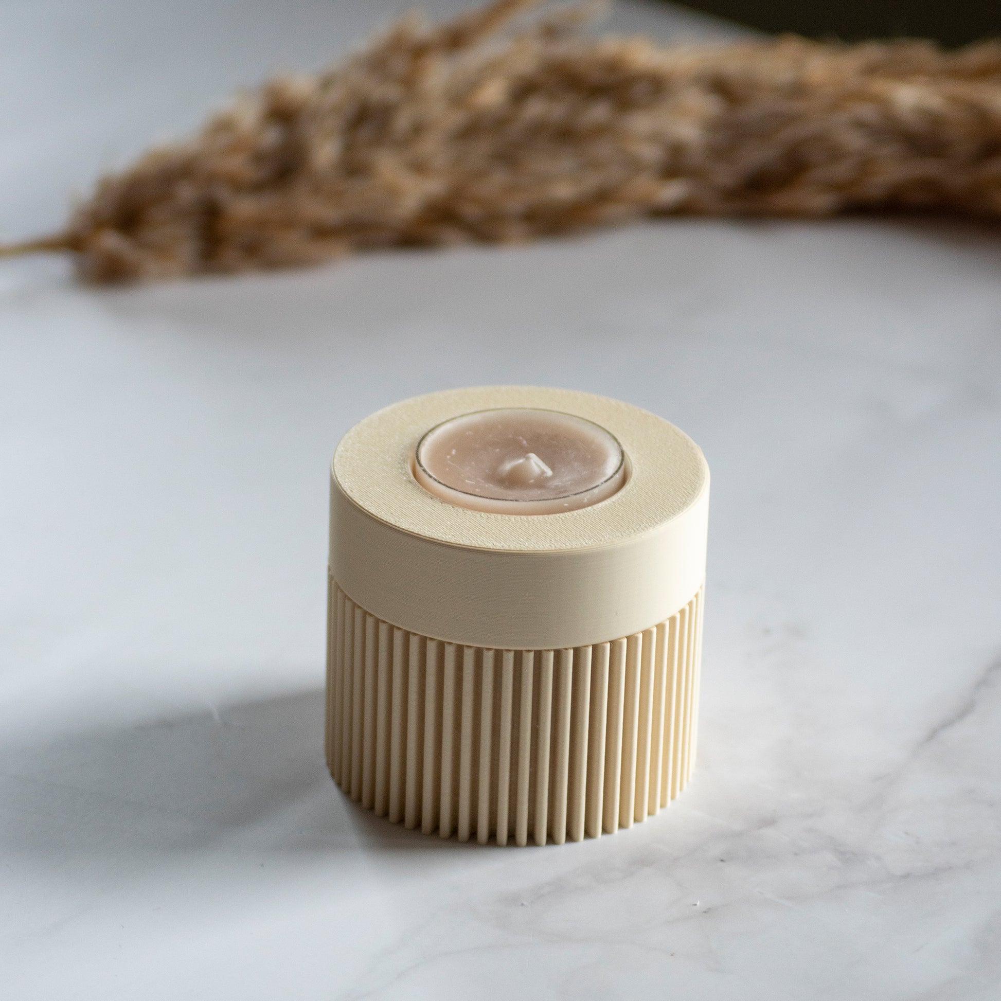 Waxinelichthouder Duo Light in kleur beige op marmeren ondergrond en rustige lichtval