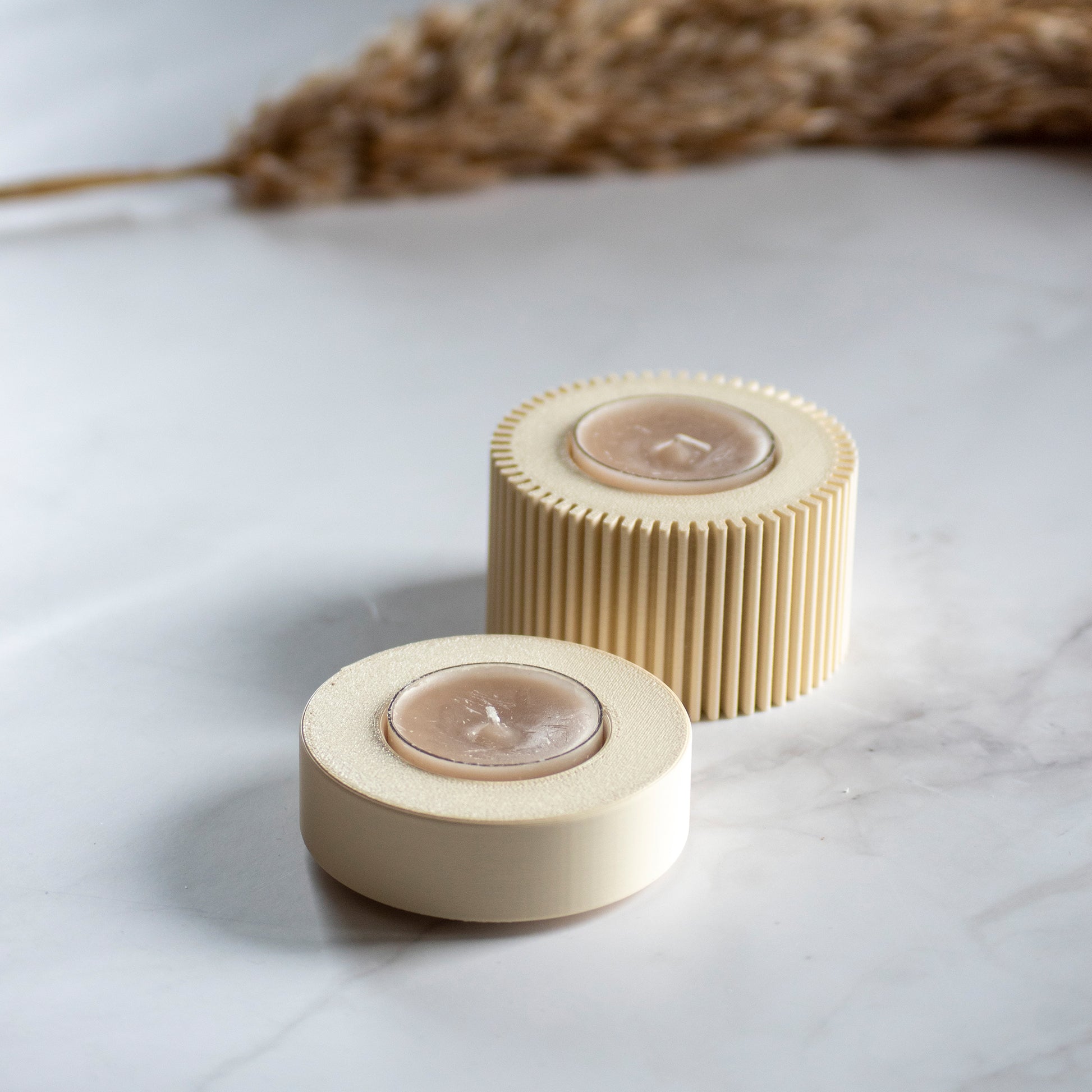 Waxinelichthouder Duo Light in kleur beige op marmeren ondergrond en rustige lichtval