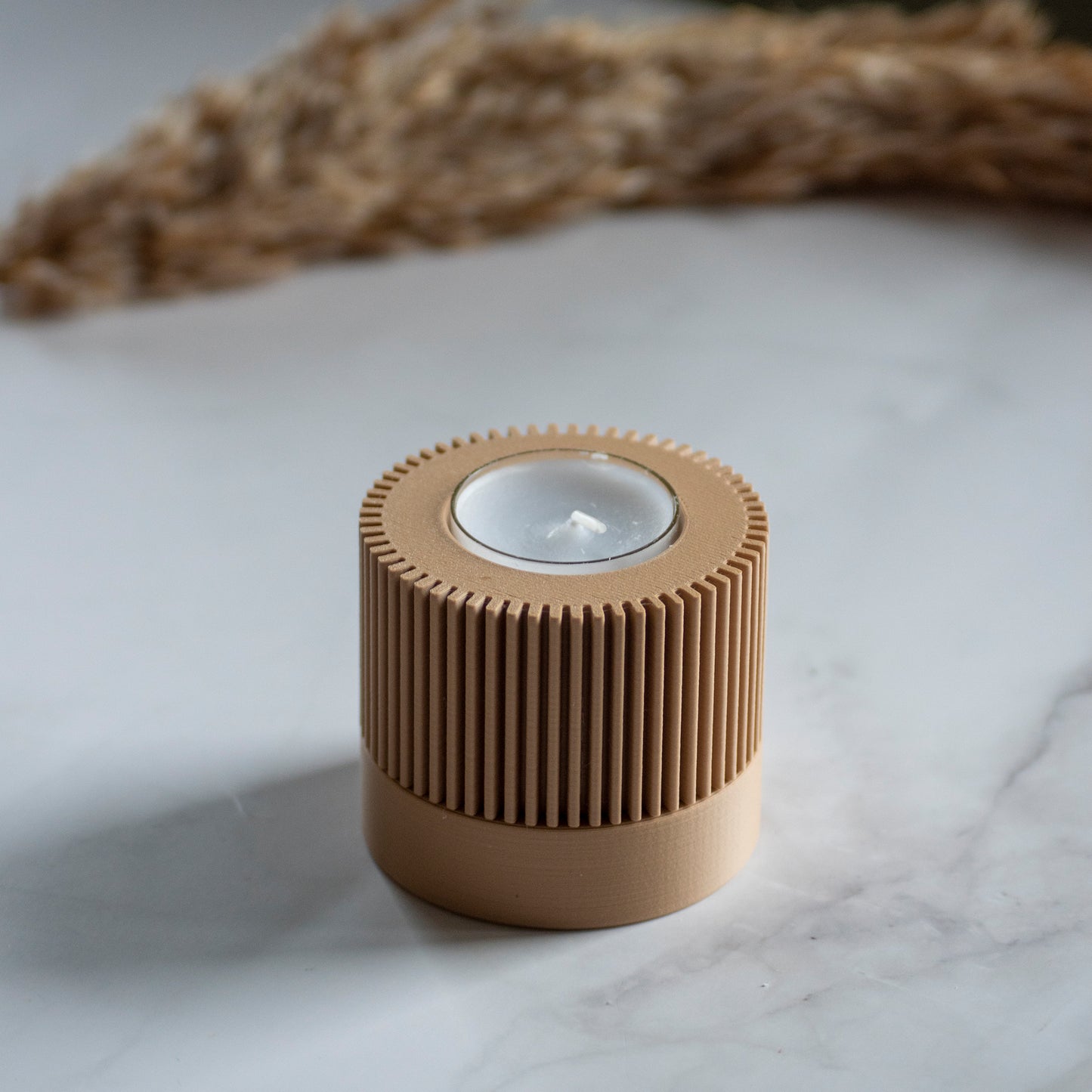 Waxinelichthouder Duo Light in kleur karamel op marmeren ondergrond en rustige lichtval