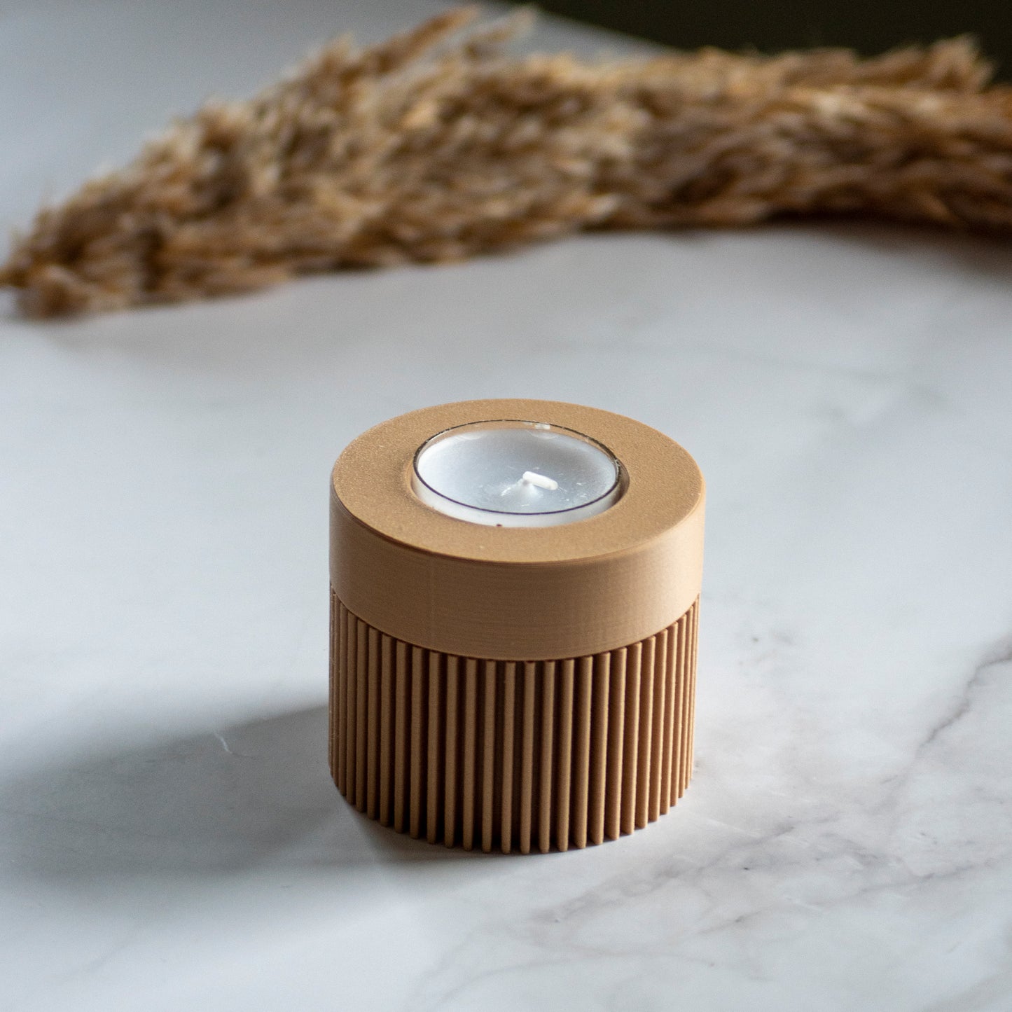 Waxinelichthouder Duo Light in kleur karamel op marmeren ondergrond en rustige lichtval