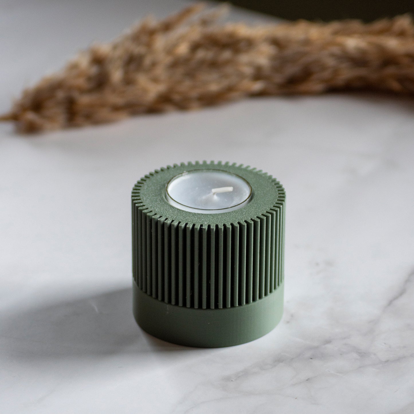 Waxinelichthouder Duo Light in kleur olijfgroen op marmeren ondergrond en rustige lichtval