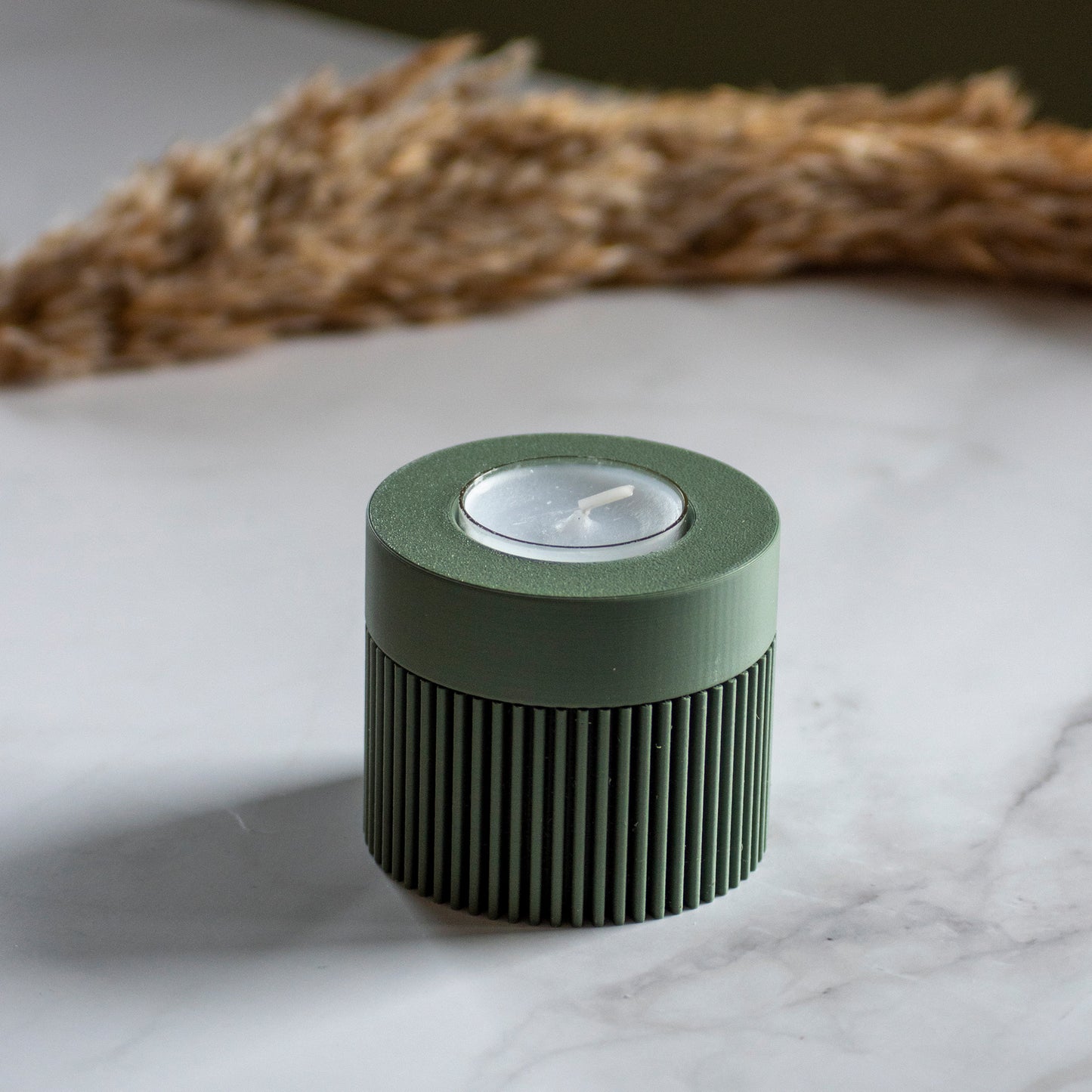 Waxinelichthouder Duo Light in kleur olijfgroen op marmeren ondergrond en rustige lichtval