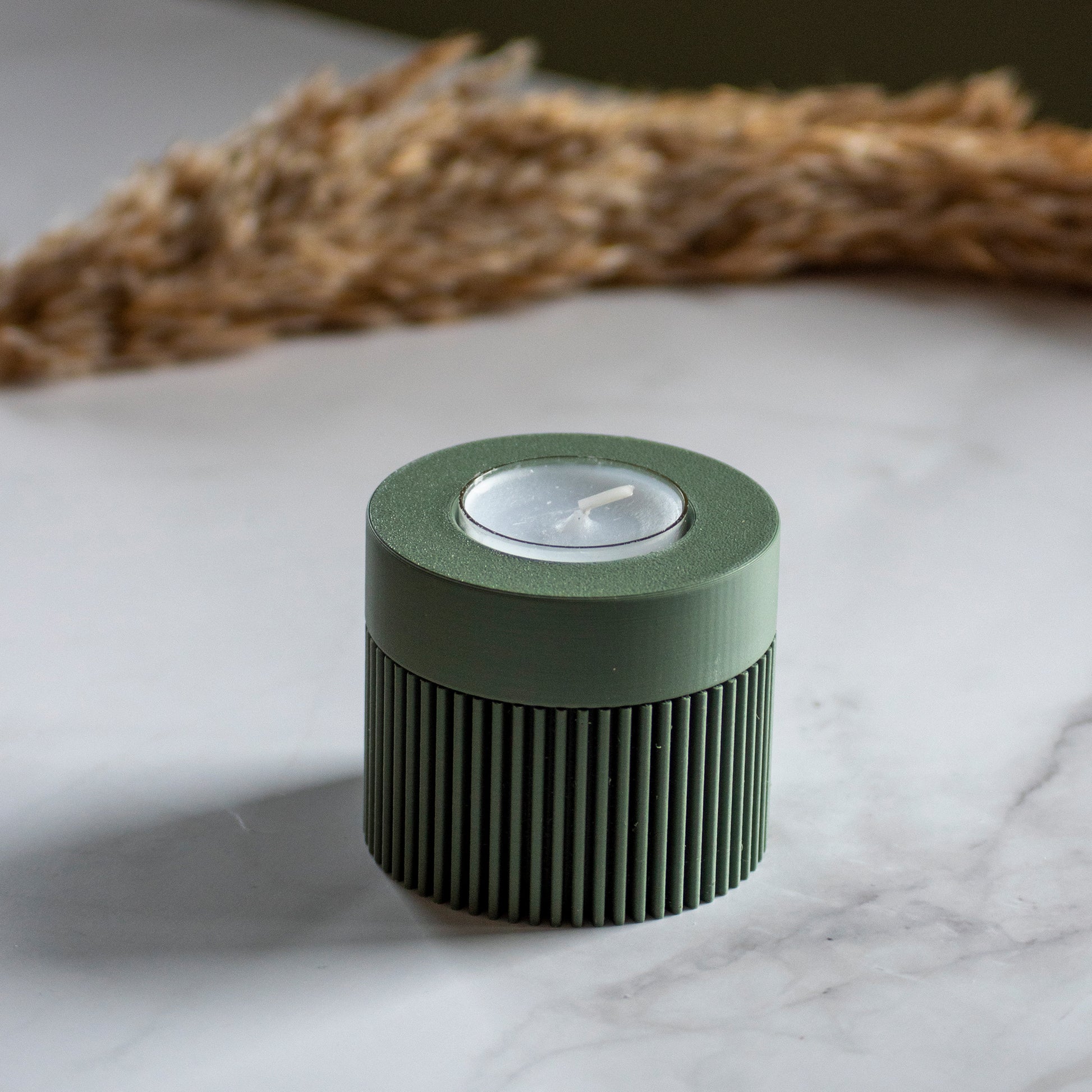 Waxinelichthouder Duo Light in kleur olijfgroen op marmeren ondergrond en rustige lichtval