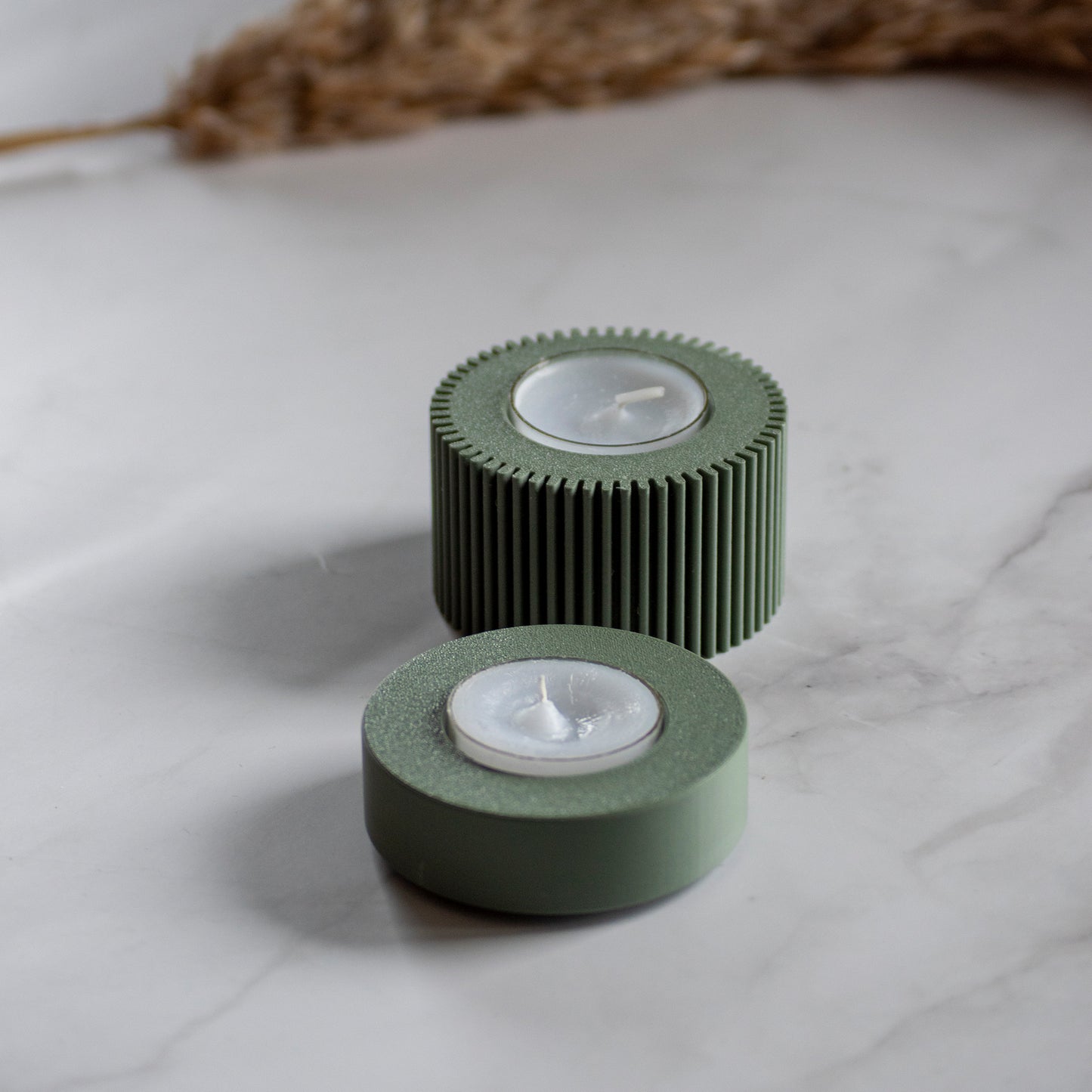 Waxinelichthouder Duo Light in kleur olijfgroen op marmeren ondergrond en rustige lichtval