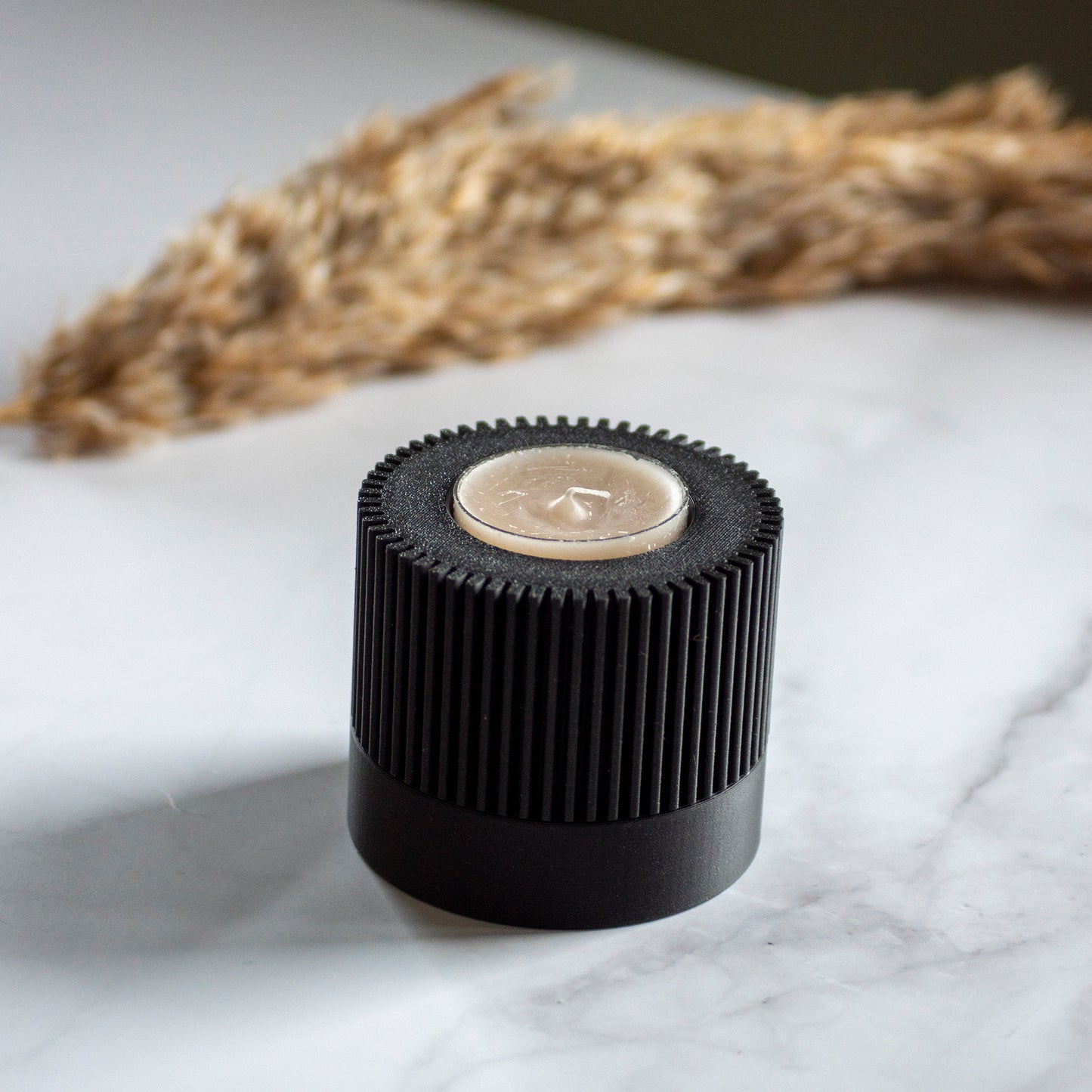 Waxinelichthouder Duo Light in kleur zwart op marmeren ondergrond en rustige lichtval