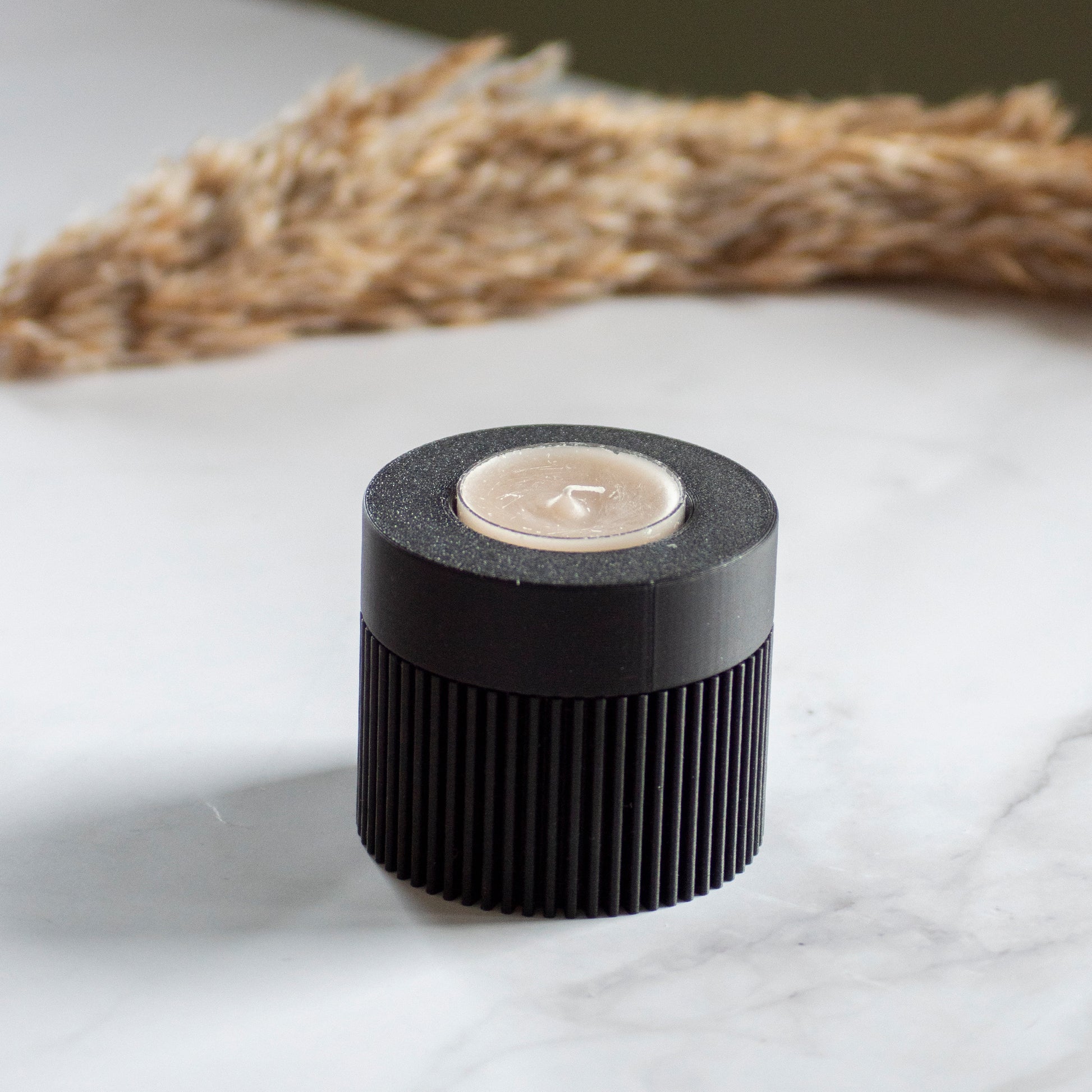 Waxinelichthouder Duo Light in kleur zwart op marmeren ondergrond en rustige lichtval