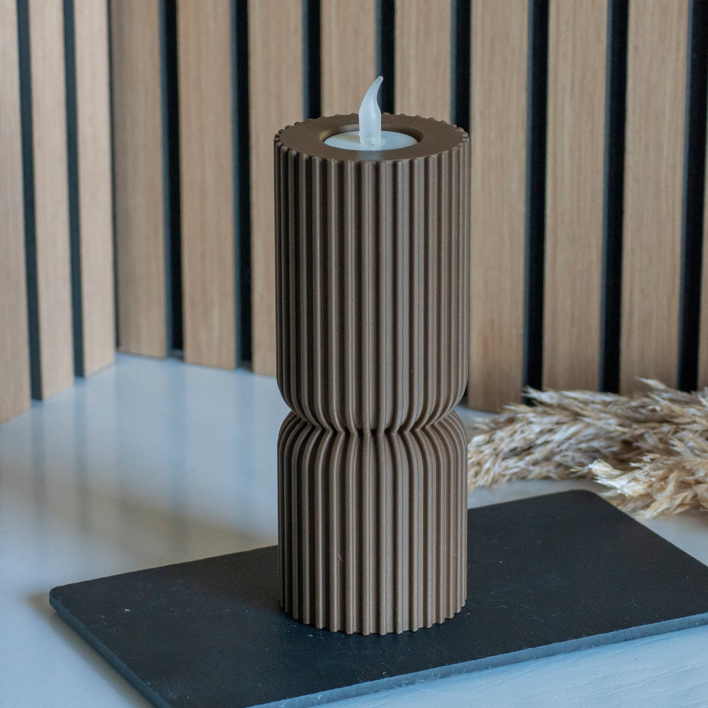 Hoge waxinelichthouder als kandelaar in kleur donkerbruin voor LED lichtjes op witte tafel en houten achtergrond
