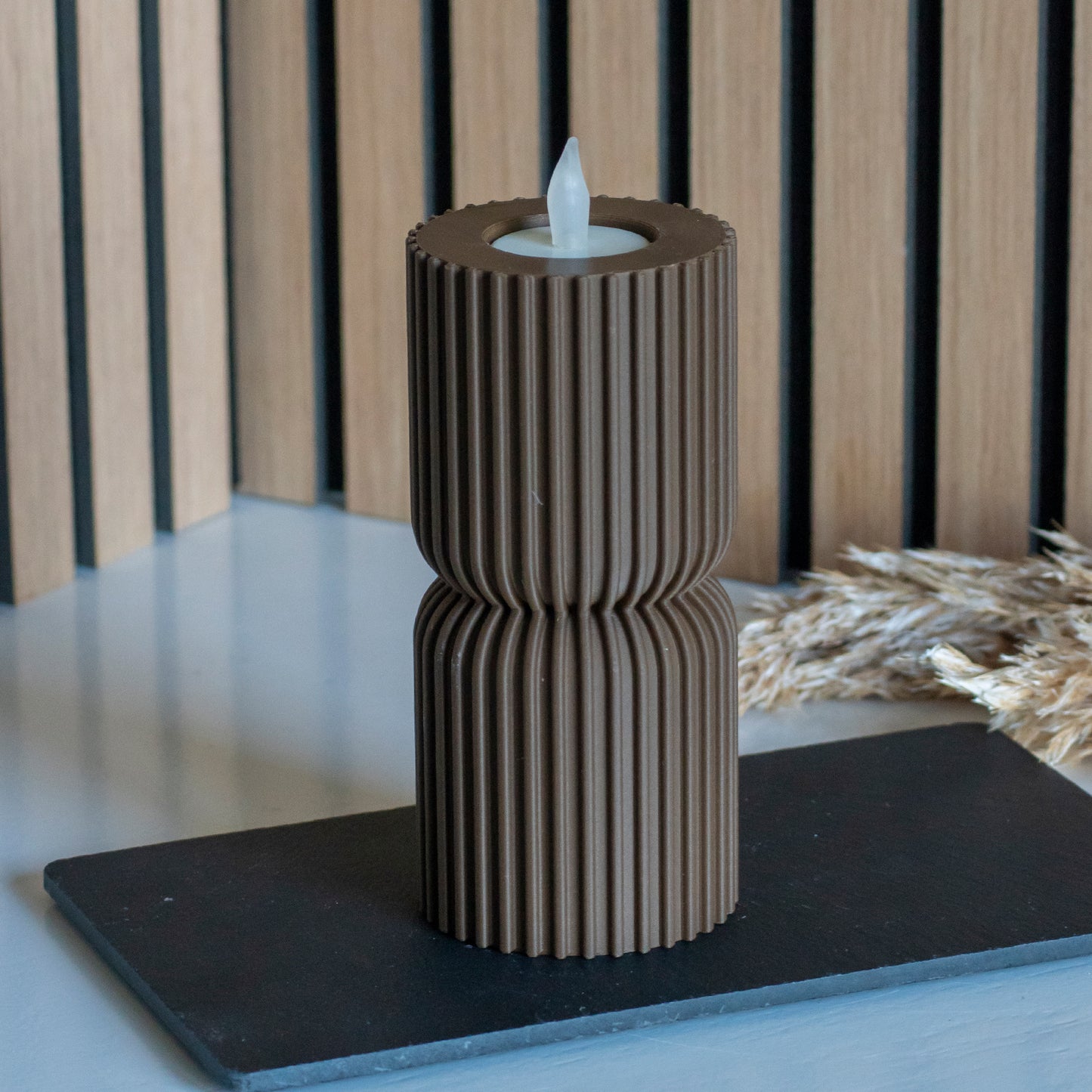 Lage waxinelichthouders als kandelaar in kleur donkerbruin voor LED lichtjes op witte tafel en houten achtergrond