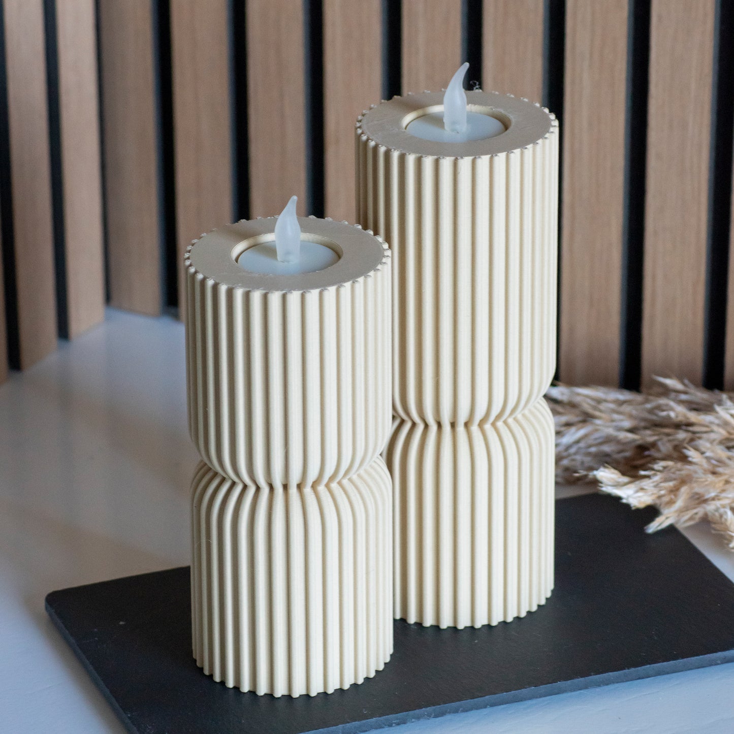 Hoge en lage waxinelichthouders als kandelaar in kleur beige voor LED lichtjes op witte tafel en houten achtergrond