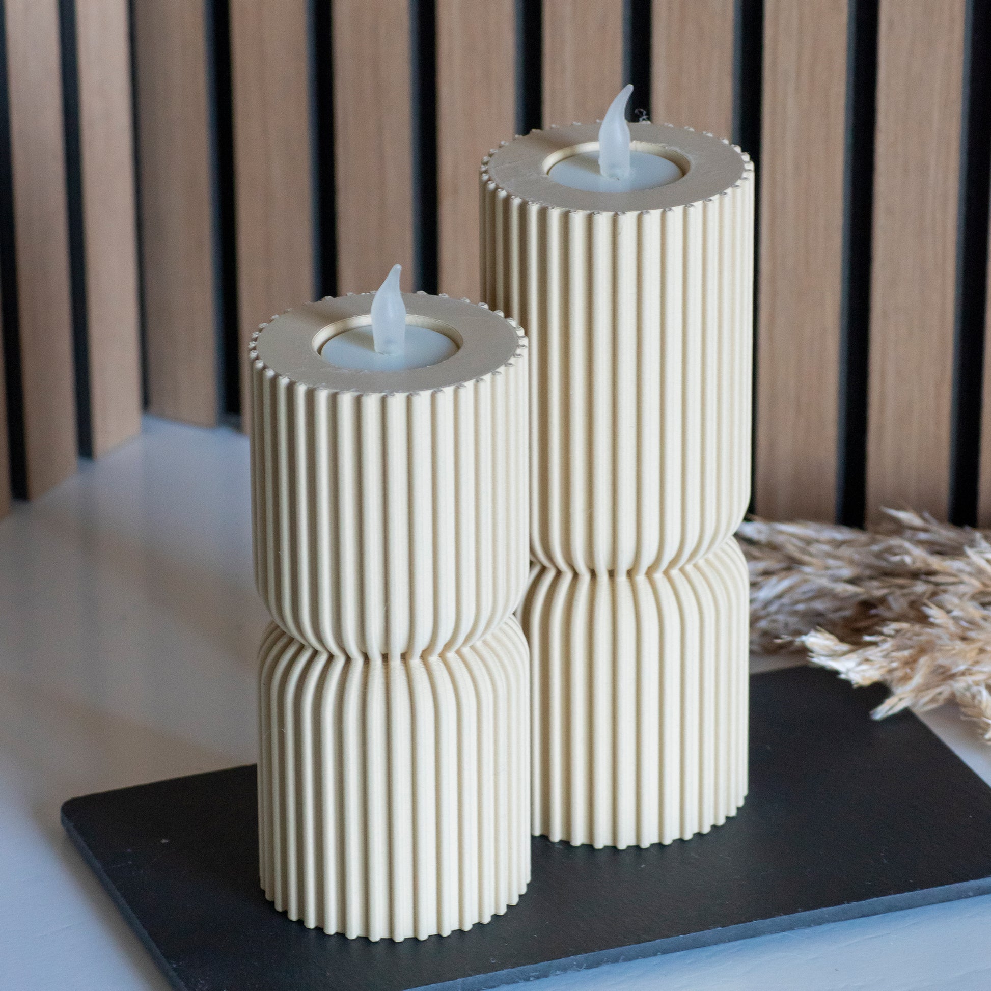 Hoge en lage waxinelichthouders als kandelaar in kleur beige voor LED lichtjes op witte tafel en houten achtergrond