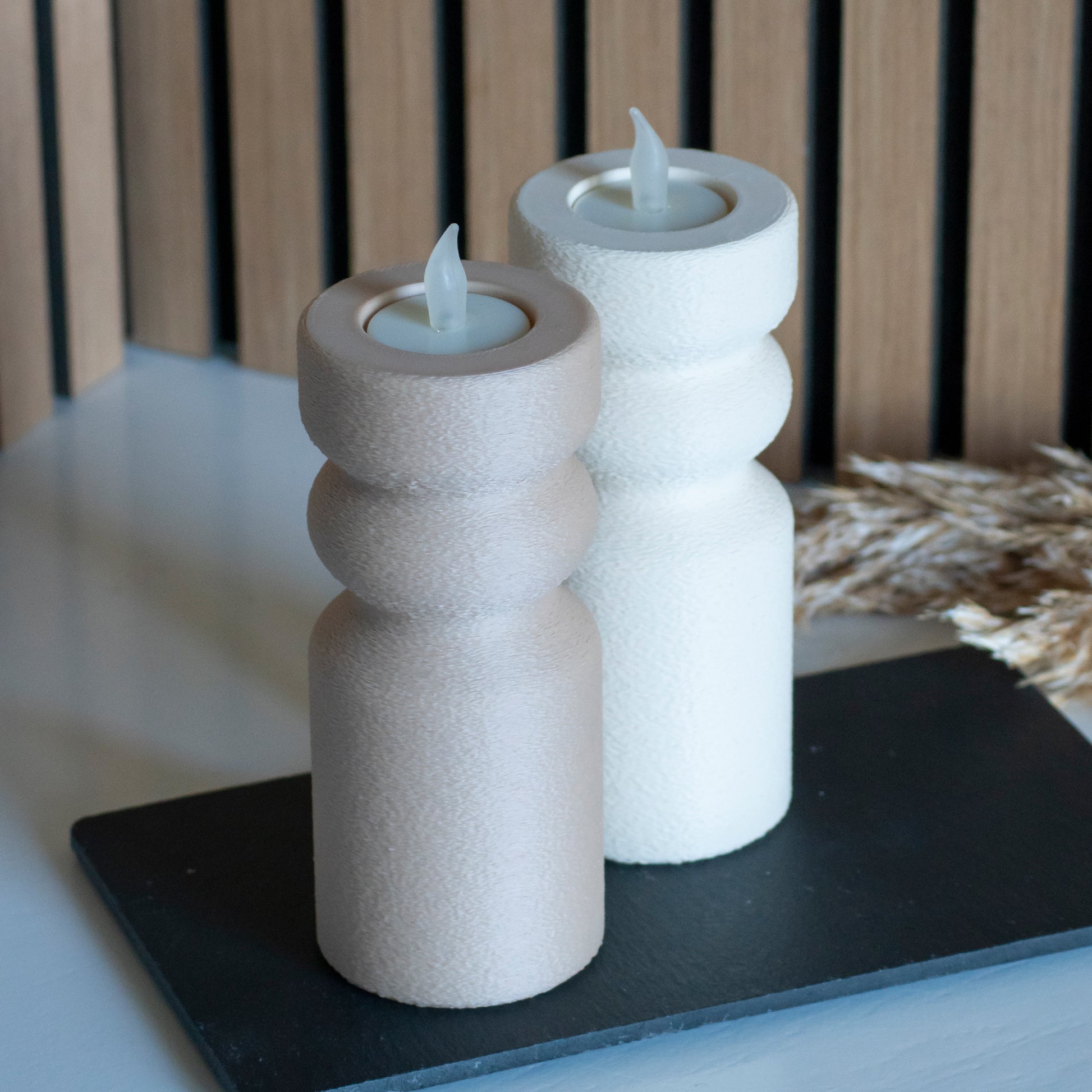 Waxinelichthouders als kandelaar in latte en beige voor LED lichtjes op witte tafel en houten achtergrond